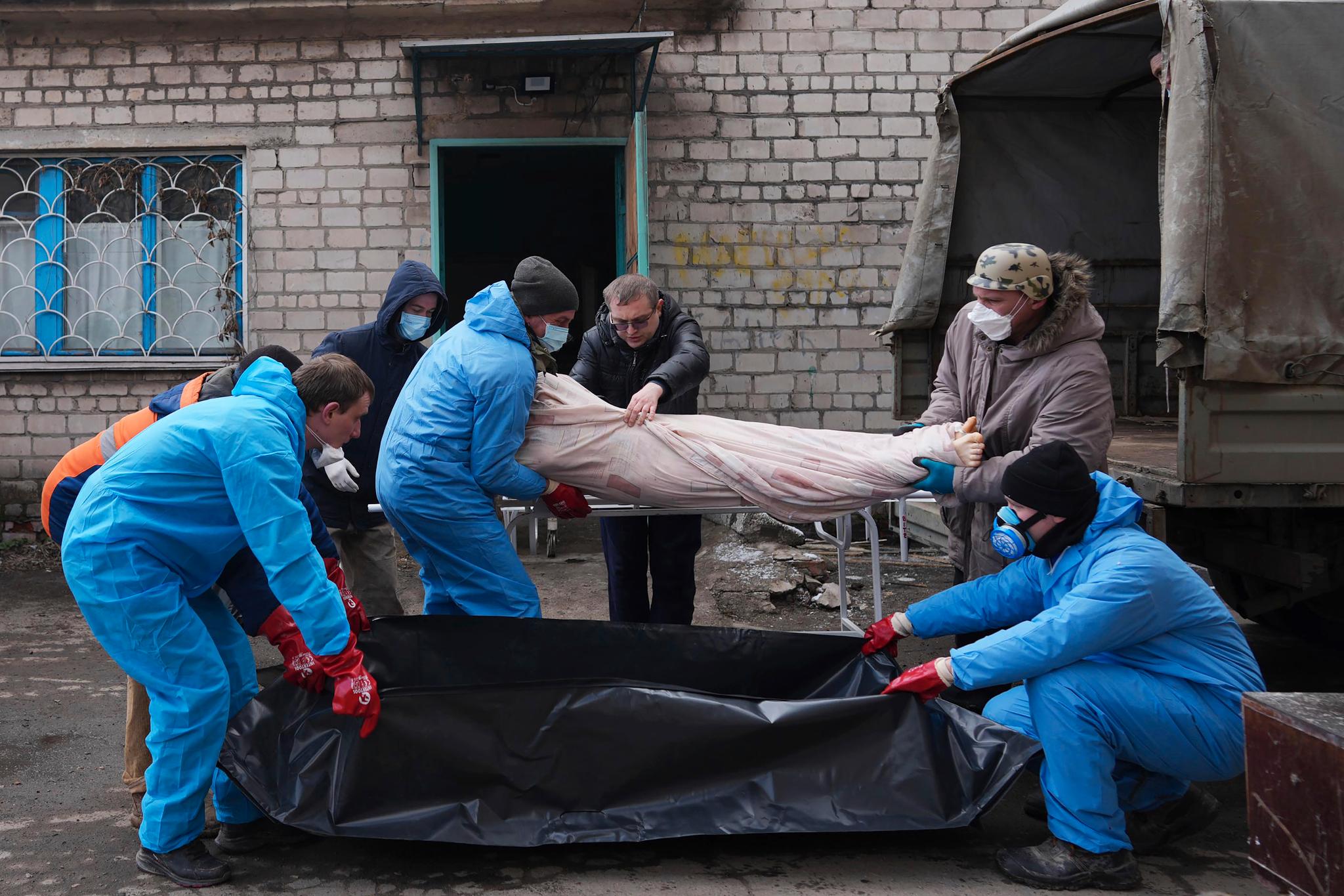 Ingen vet hvor mange sivile som er drept så langt er drept i Russlands invasjon av Ukraina. Her flyttes ofre ut av et likhus i Mariupol 9. mars. 