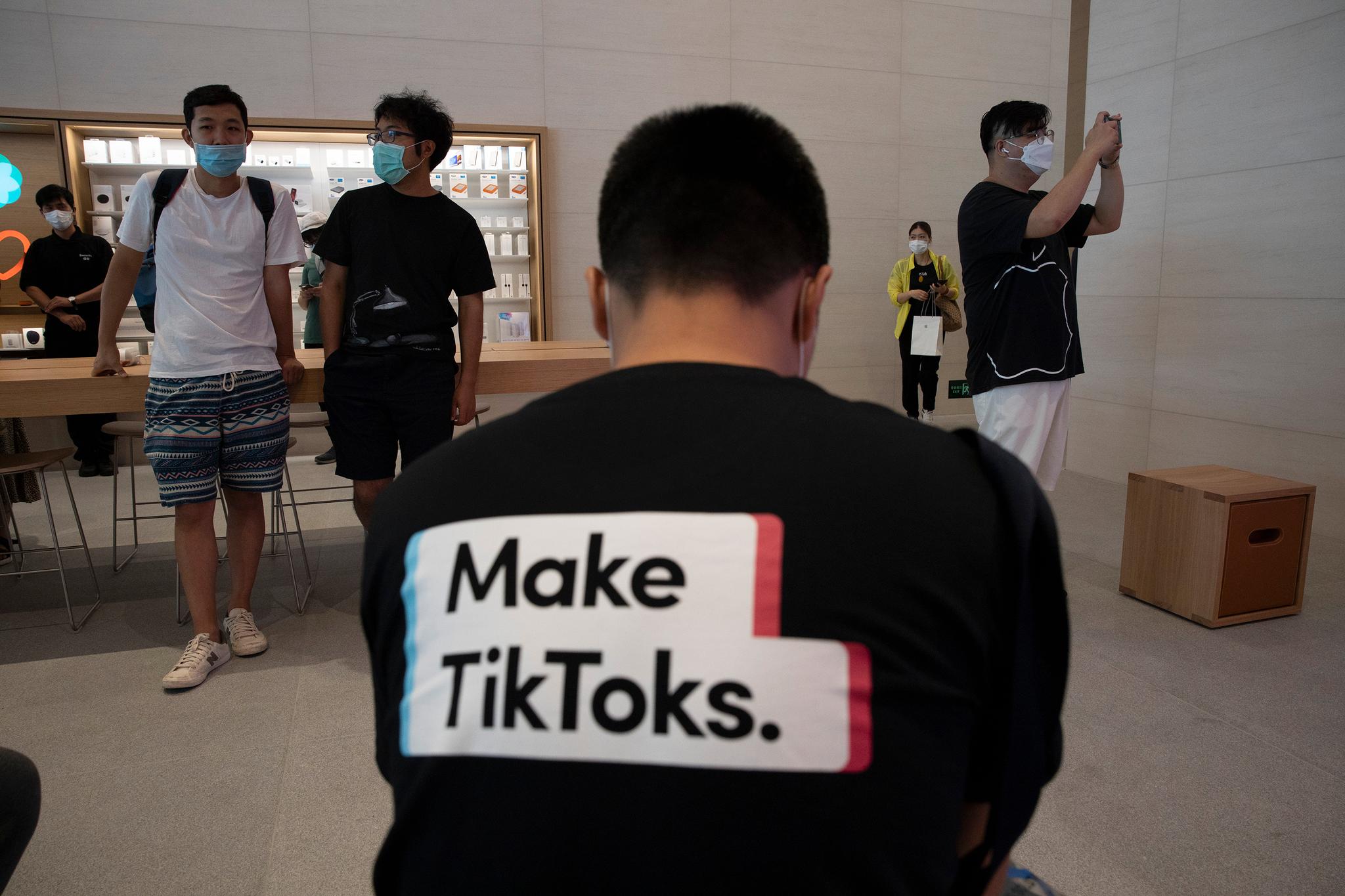 En mann reklamerer for Tiktok i en Apple-butikk i Kina i sommer. 