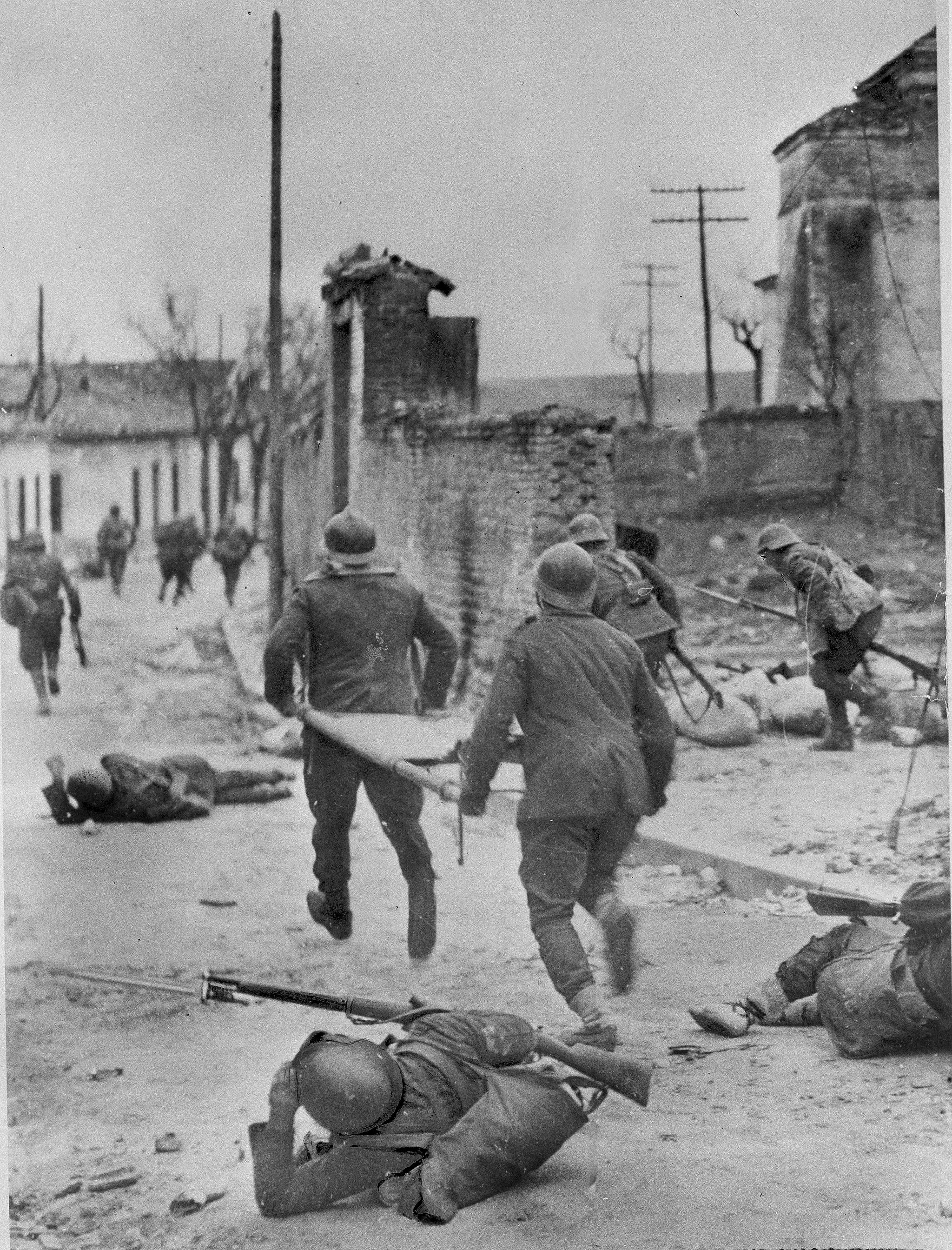 Blodsutgytelsene etterlot seg en halv million døde, hvorav ca. 200.000 på slagmarken. Bildet er fra utkanten av Madrid 15. oktober 1937 og viser bårebærere blant sårede soldater. 