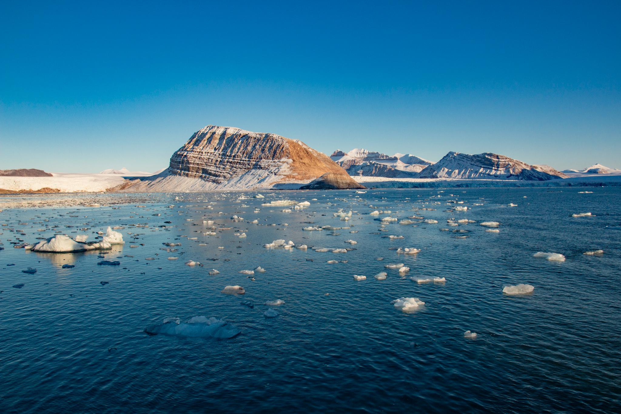 Forskere i Norge og Finland har studert temperaturdata fra Arktis og kommet frem til at regionen varmes opp betydelig raskere enn det man hittil har trodd. Isen på bildet kommer fra isbreer som kalver ut i Kongsfjorden ved Ny-Ålesund på Svalbard. 