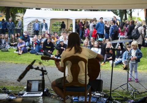 LIVE: Publikum lyttet til musikken og slappet av i solen mens Carl Tomas Nising Sandvold sang og spilte gitar under Munkehagen 2015.