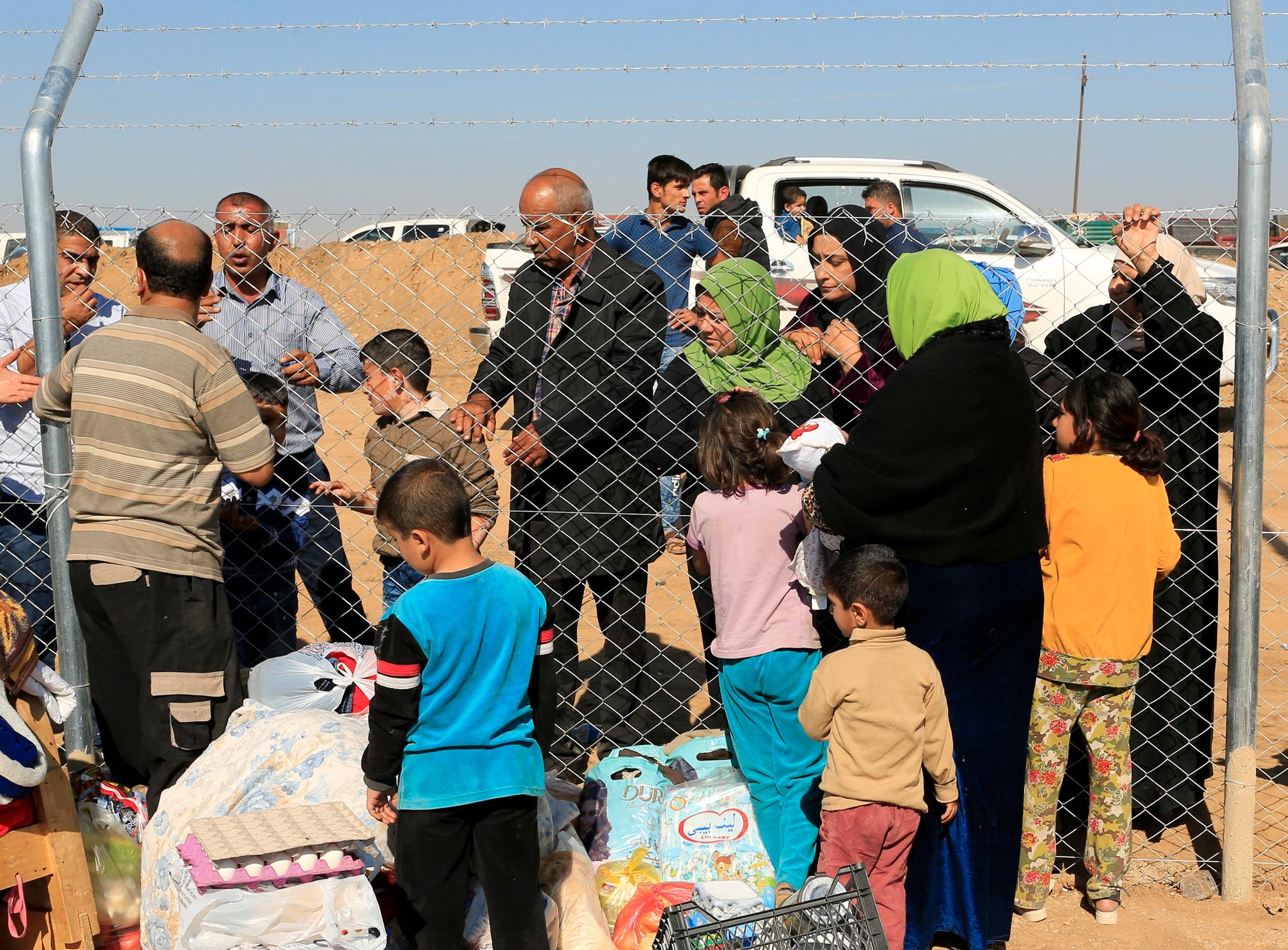 Folk blir gjenforent med slektniger som har flyktet fra Mosul ved Al-Khazeer-flyktningleiren øst for Mosul.