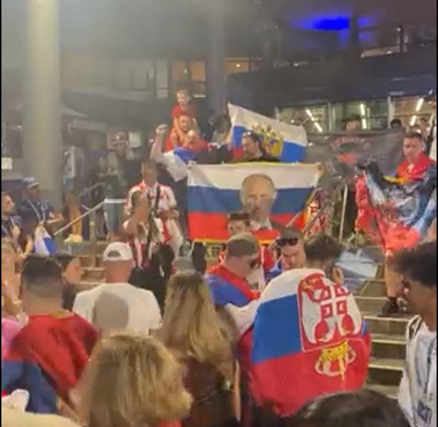 PUTIN-FANS: Russiske tennisfans hyllet Vladimir Putin utenfor stadion i Melbourne. Det endte med pågripelse for fire av dem. På tribunen var det også serbiske flagg. 