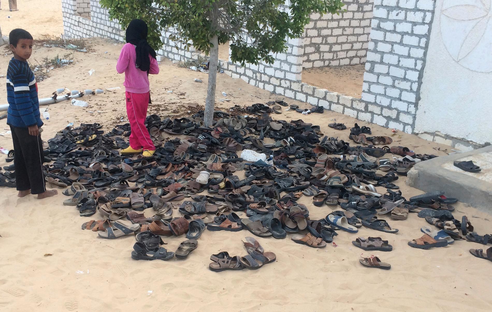 FORLATT: Skoene til noen av de over 300 ofrene for massakren, lå fortsatt utenfor Al-Rawda-moskeen i Nord-Sinai lørdag.