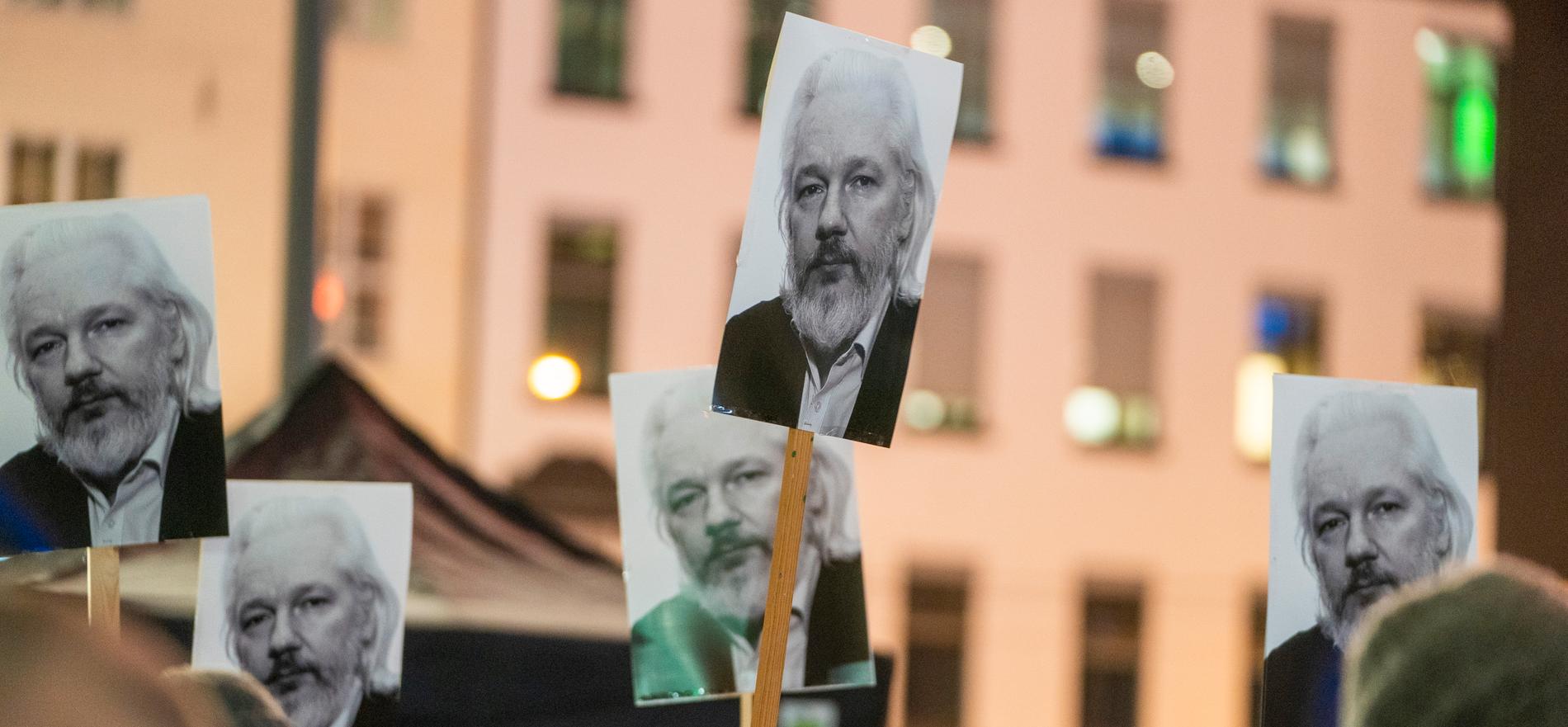 Plakater med Julian Assange under en lysmarkering i forbindelse med fredsprisen 2021. 