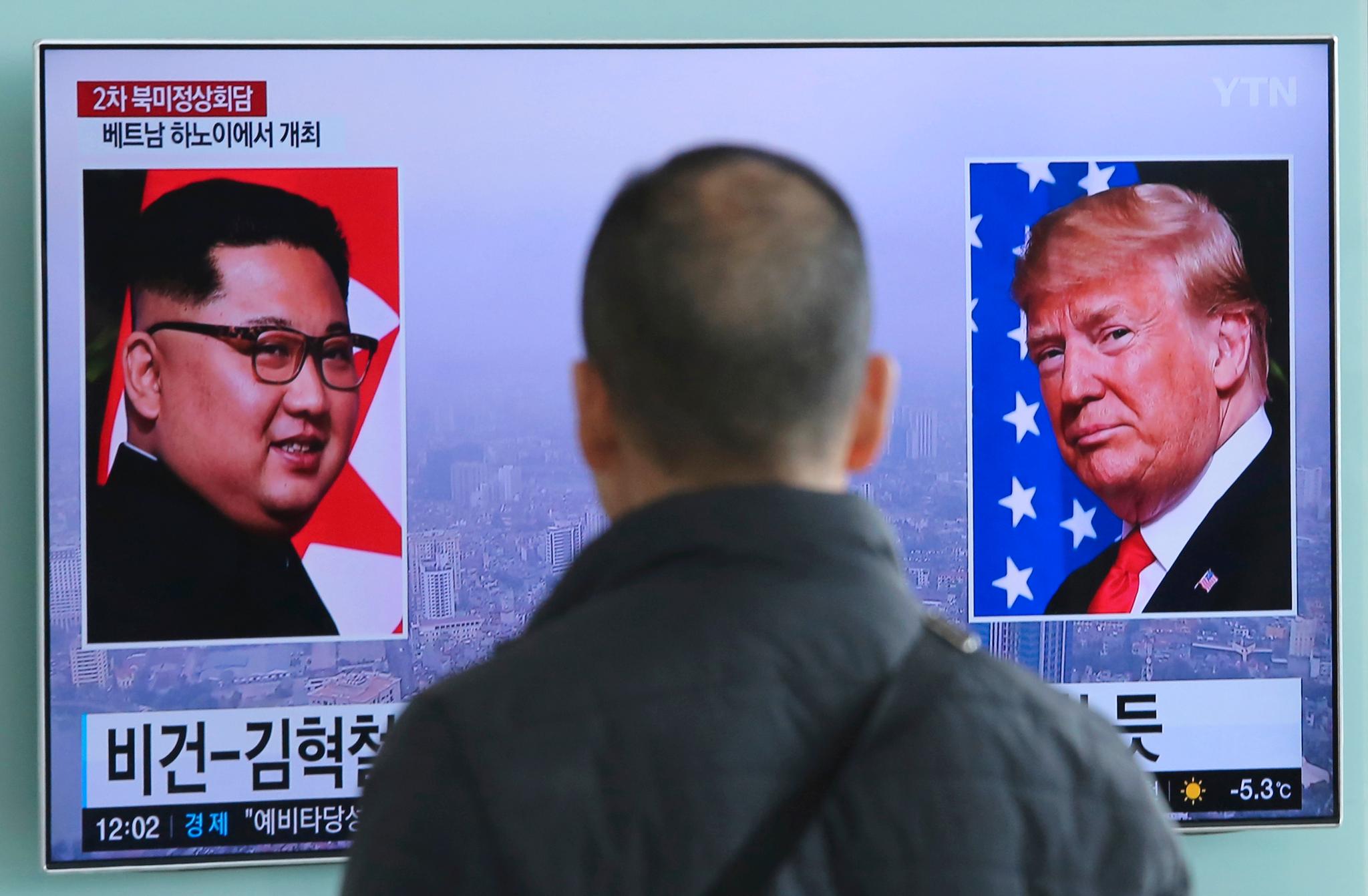 En mann i Seoul i Sør-Korea ser på en TV-skjerm av Nord-Koreas leder Kim Jong Un og USAs president Donald Trump. 