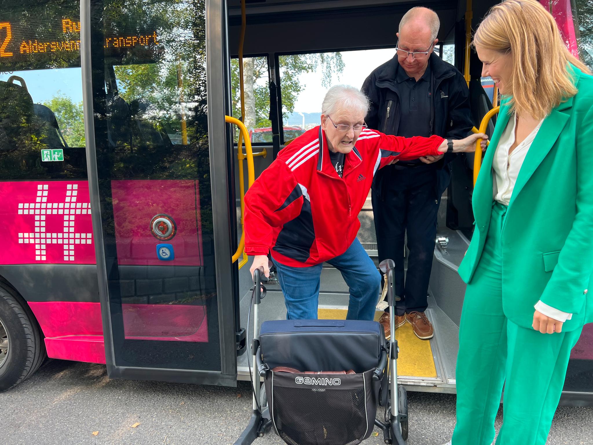 Grete Breson (89) er storfornøyd med aldersvennlig transport og bruker de rosa bussene to-tre ganger i uken. Her sammen med sjåfør Steinar Hansen og byråd Sirin Stav (MDG).