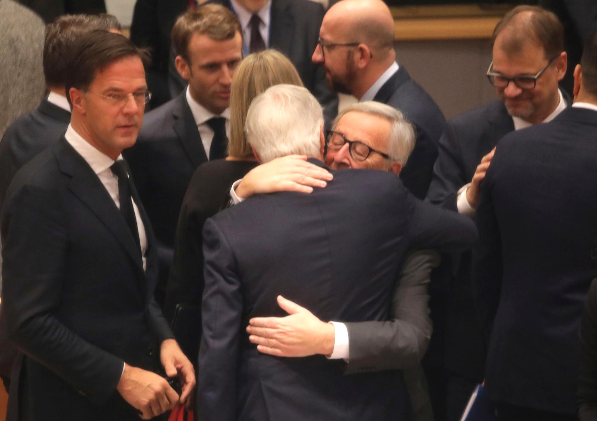 EU-kommisjonens president Jean-Claude Juncker omfavner sin brexit-sjefforhandler Michel Barnier. Preget av følelser var også Frankrikes president Emmanuel Macron og Nederlands statsminister Mark Rutte.