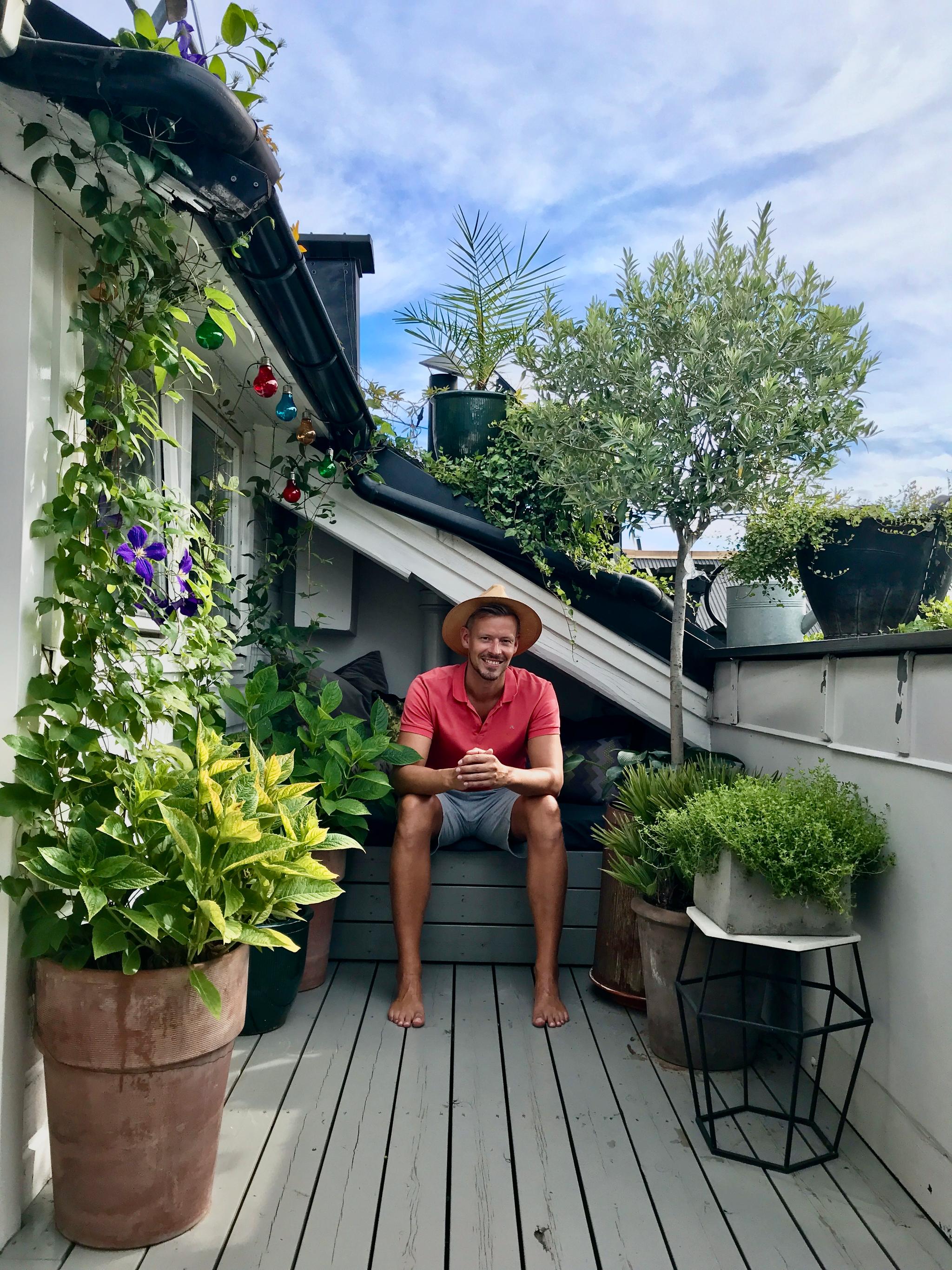 Anders Røyneberg på balkongen på Grünerløkka. Her laget han en oase av vekster på en relativt liten plass. – Her ble det både lunt og varmt, perfekte forhold for krukker med middelhavsurter som timian og oregano, oliventre, eføy og den flerårige klatreplanten klematis, sier han.