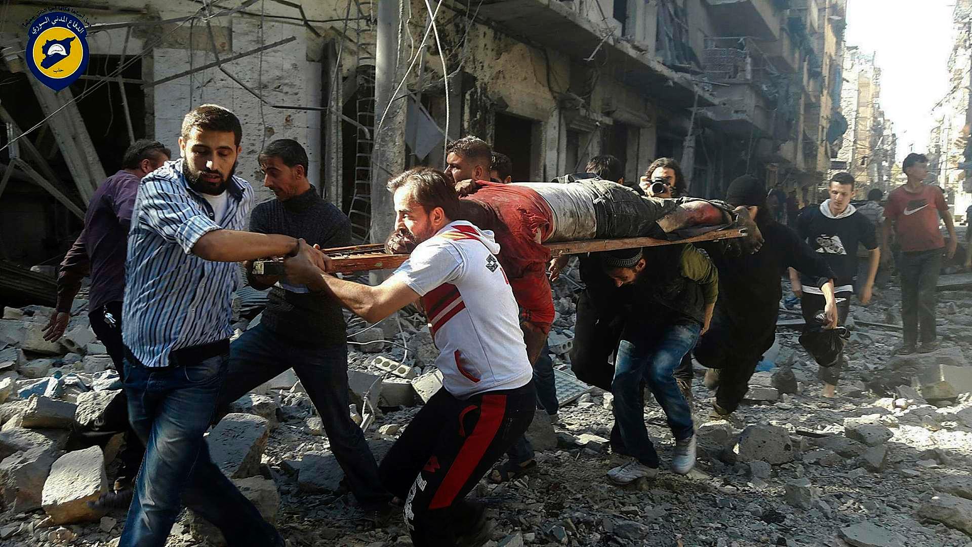 En mann som er blitt skadet i et bombeangrep i den opprørskontrollerte delen av Aleppo blir båret bort på en båre. Bildet er skaffet til veie av gruppen som kaller seg De hvite hjelmene, som har som sin hovedoppgave å hente skadede personer ut av sammenraste hus for så å frakte dem til sykehus.