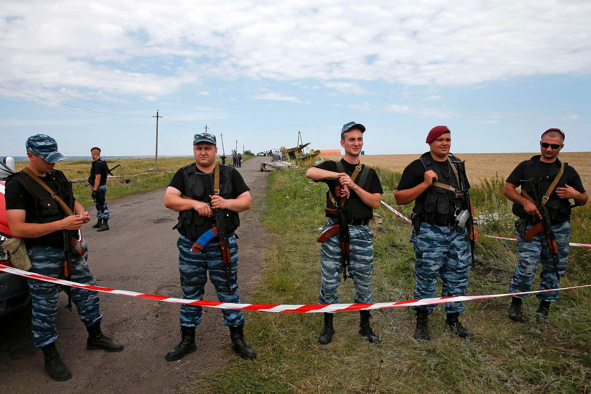 Russiskstøttede opprørere holder vakt ved vrakdelene etter passasjerflyet MH 17 i Donetsk. I dag presenteres rapporten som skal vise hvor flyet ble skutt fra.