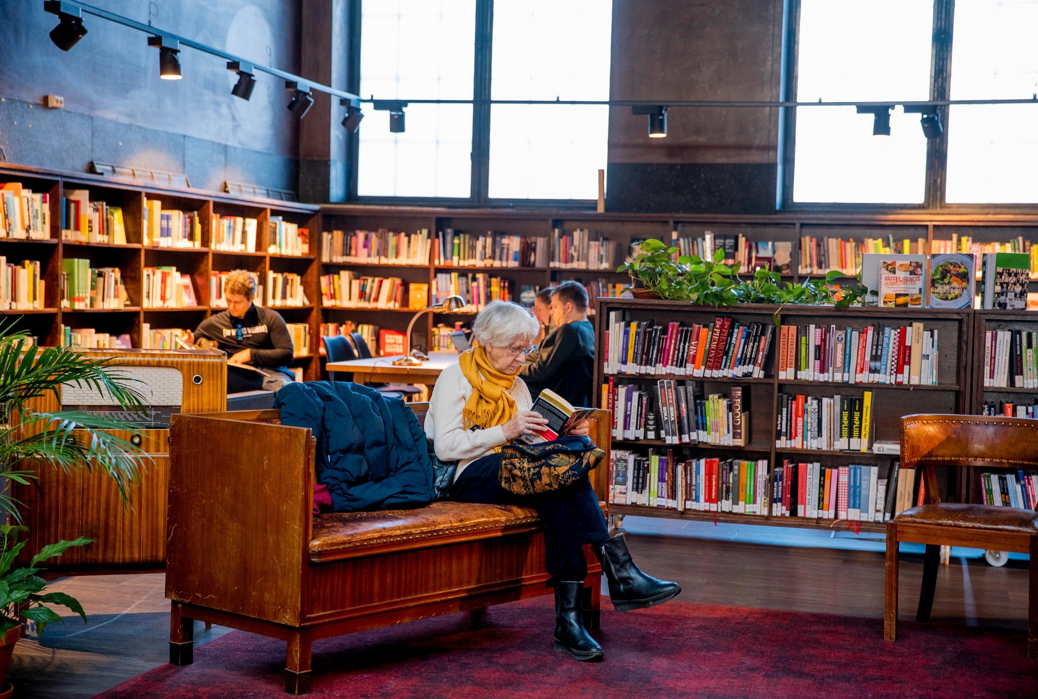 Kari Østensen (87) sitter konsentrert og leser. Sist gang hun var innom biblioteket var for 40 år siden. 