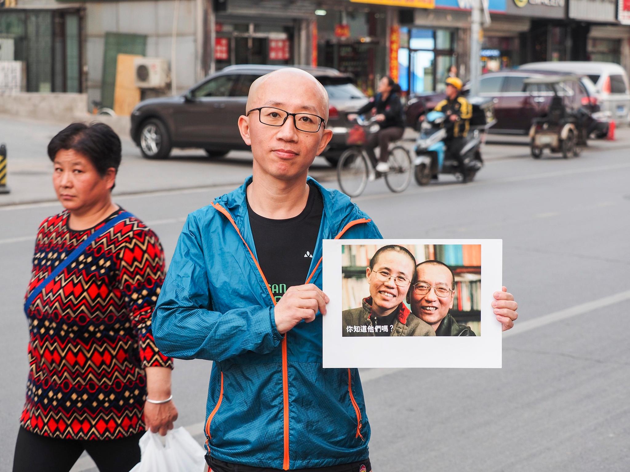  Aktivisten Hu Jia viser frem portrettet av sine venner, nobelprisvinner Liu Xiaobo og hans kone Liu Xia foran Erna Solbergs Kina-besøk i april 