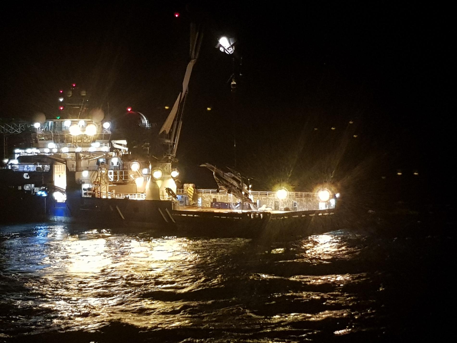 Klokken 2 natt til lørdag ble skroget med rotor og den separerte halebommen fra det havarerte helikopteret hevet opp på dekk på skipet Maersk Forza. Foto: Politiet / NTB scanpix