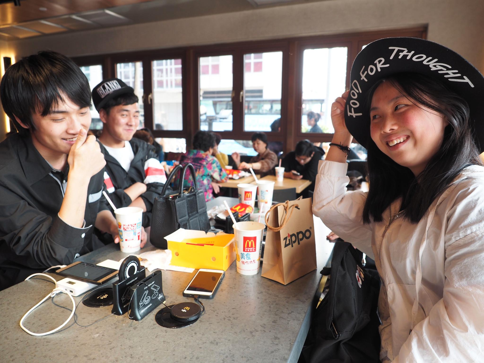 Yan Jingjing (th) og  Dong Sheng Yan liker maten og det de beskriver som cool stemning på McDonalds.  I bakgrunnen t.v: Tian Yu.