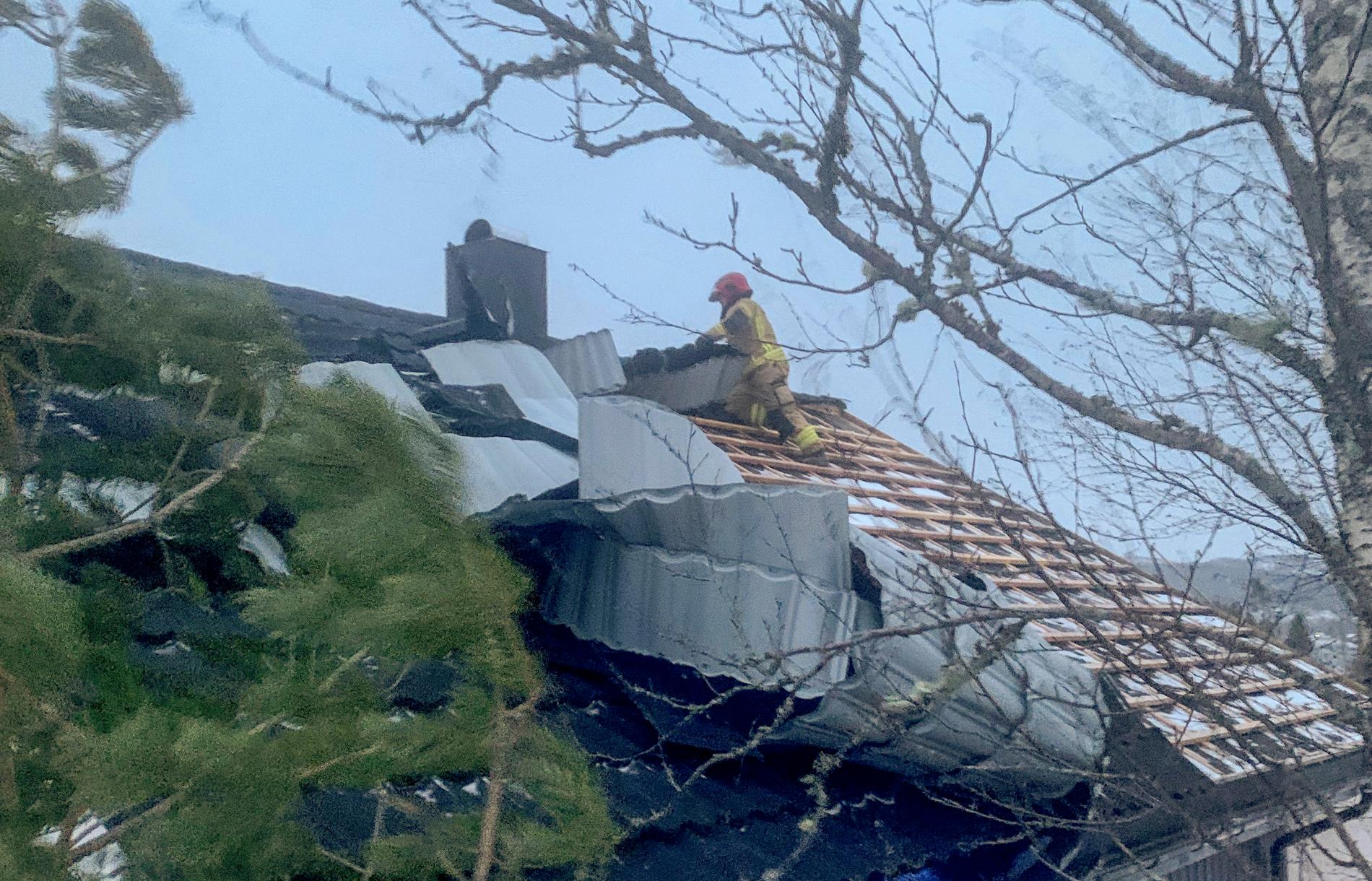 Mannskaper fra brann- og redningsetaten i Namsos sikrer taket på et hus i Ramsvikskogen der takplater løsnet i den sterke vinden. 
