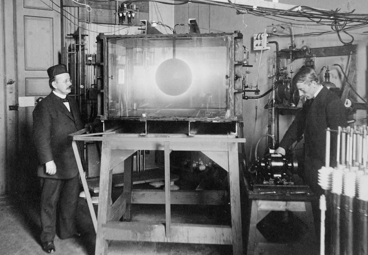 Kristian Birkeland bygde sitt eget lille verdensrom med Terella-eksperimentet for å bevise at det var partikler fra Solen som skapte nordlys. Bildet fra 1910 viser Birkeland (til venstre) og hans assistent Olaf Devik.