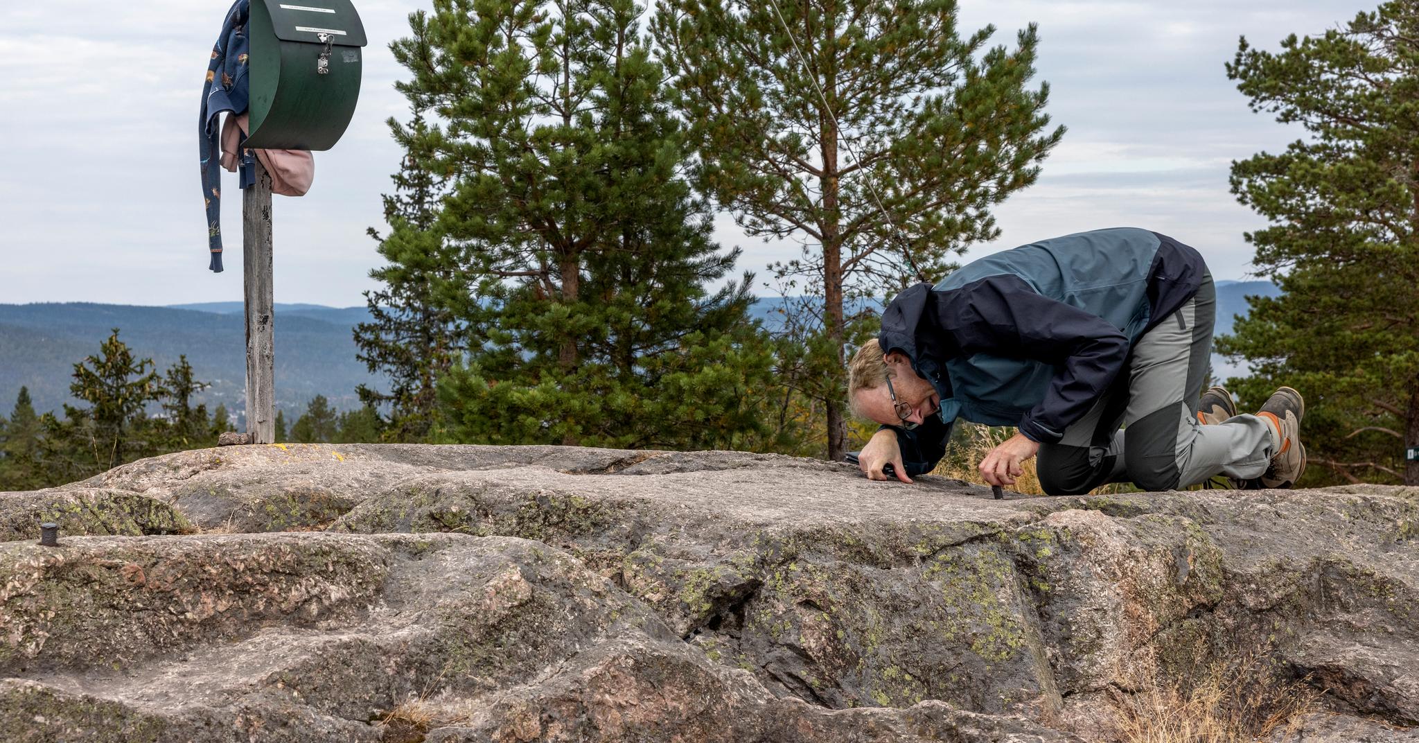 Sveinung Engeland, fjellentusiast og journalist, har tatt frem målebåndet. Ifølge skiltet er Kolsås-toppen 379 moh, men ifølge siste måling befinner toppunktet seg  380 moh.