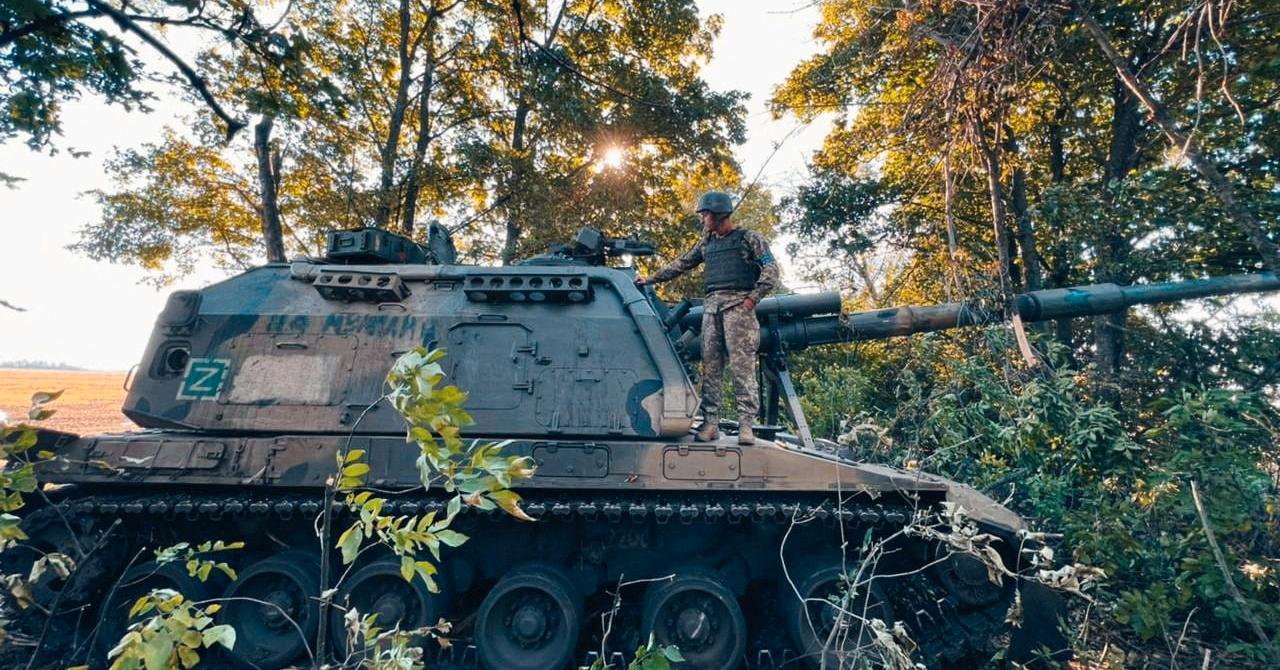 En ukrainsk soldat står på en russisk selvgående haubits av typen 2S19 Msta. En rekke pansrede kjøretøyer og våpen står igjen etter at russiske styrker er på retrett i Kharkiv fylke.