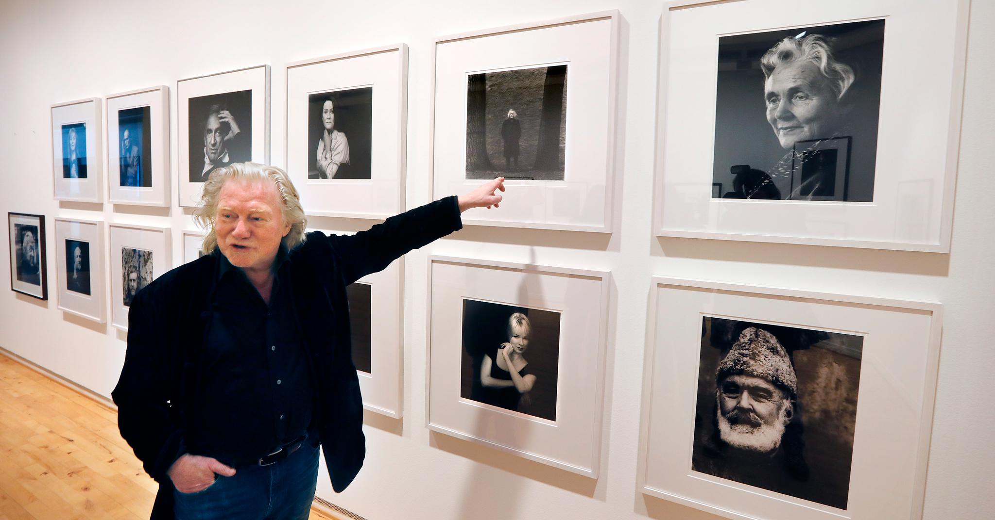 Fotokunstneren Morten Krogvold foran rekken av kjente portretter, som han nå viser i Tønsberg. Her peker han på forfatteren Dag Solstad. – Når vi snakker om forfattere og kunstnere er nemlig saken den at en kunstner lever av sin egen sårbarhet. Tvilen er sterkt til stede, sier Krogvold.