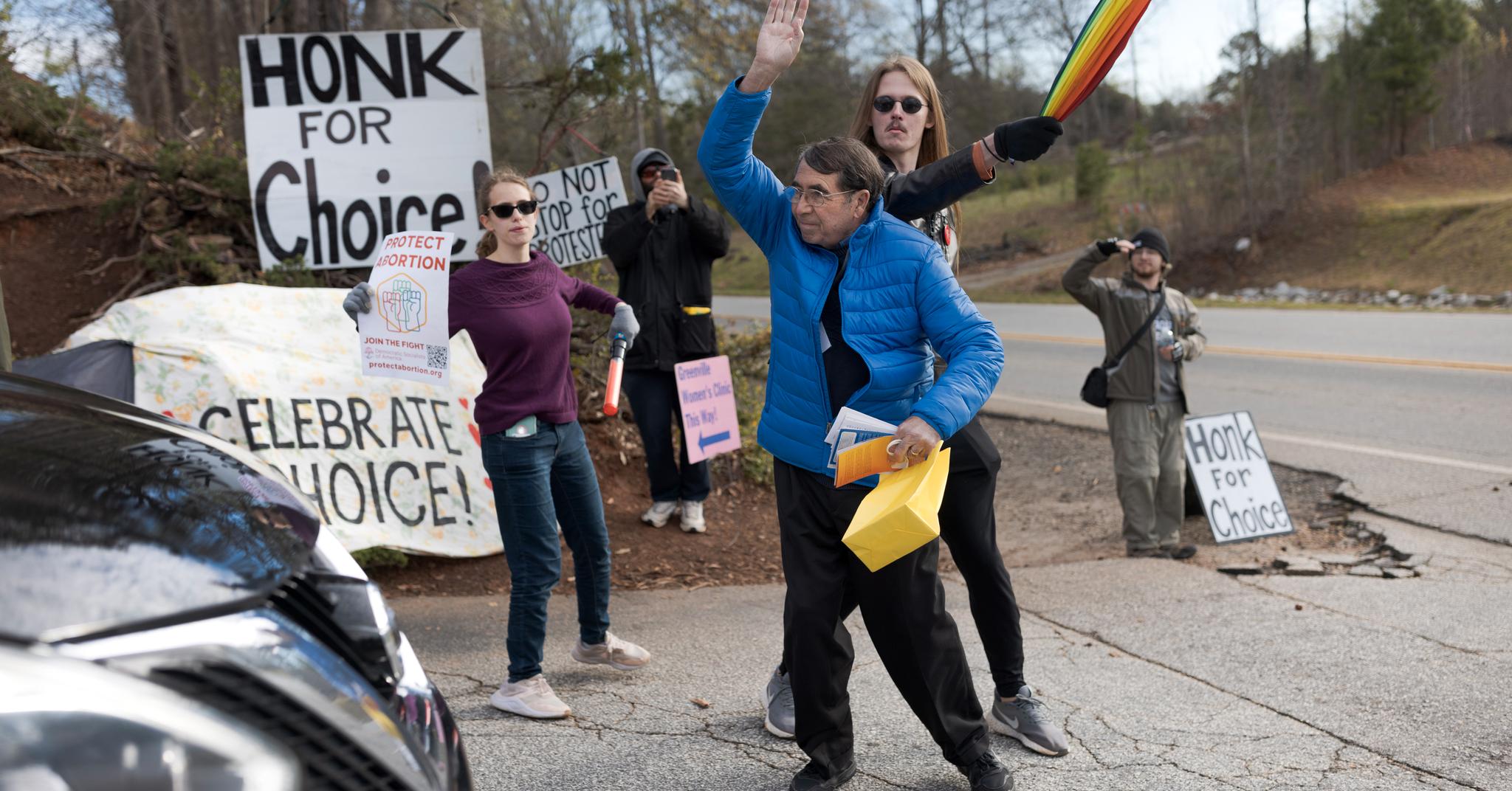 Abortmotstander Jim (i blått) kjemper for å komme seg forbi motdemonstrant Steven Raney utenfor en abortklinikk i Greenville i Sør-Carolina. 