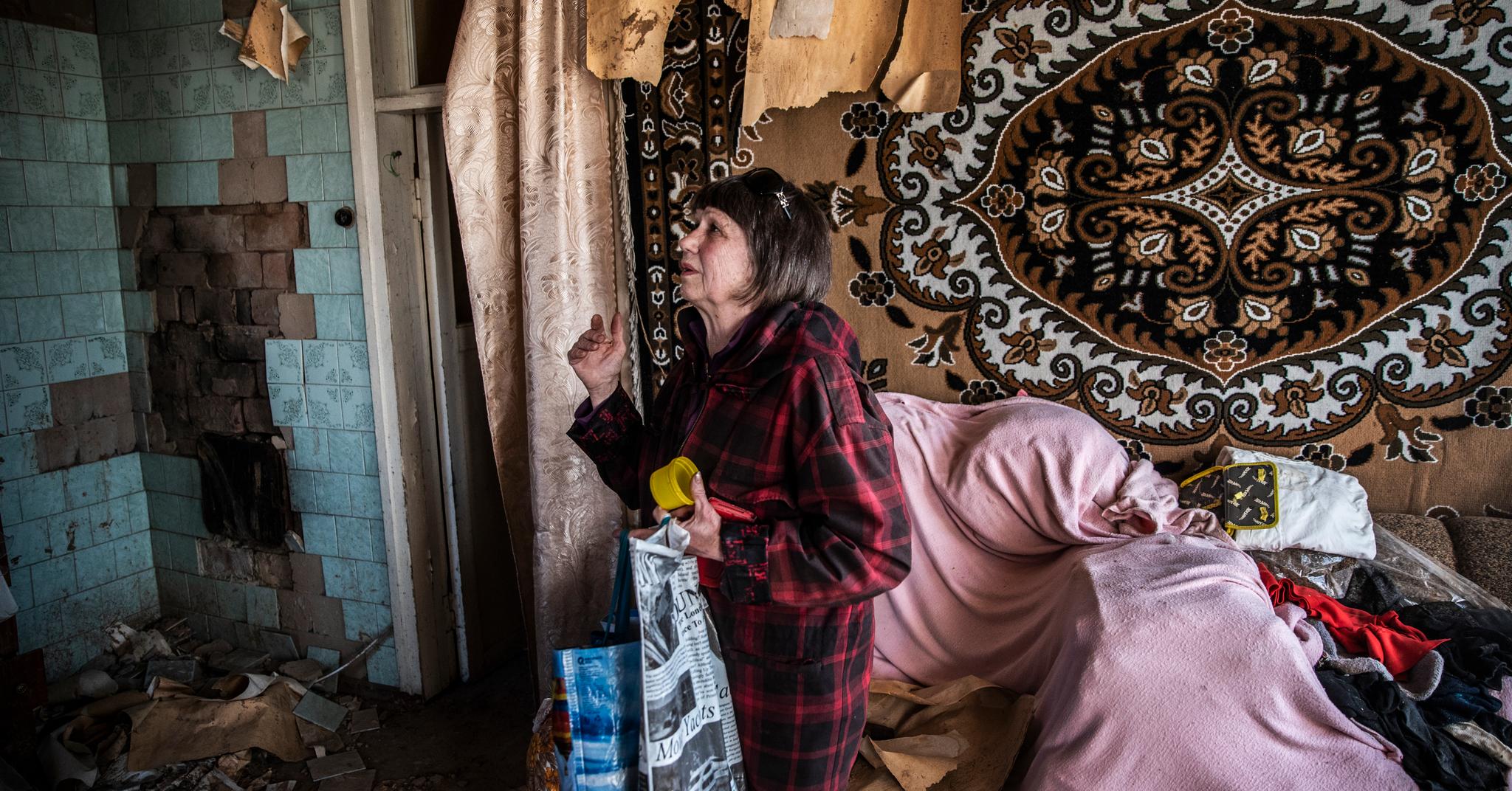 Tatiana (69) ser over skadene i barndomshjemmet hun vokste opp i. Før invasjonen bodde nevøen hennes her. Da russiske soldater kom, flyktet han med familien sin. 69-åringen ble igjen for å mate etterlatte dyr under okkupasjonen.