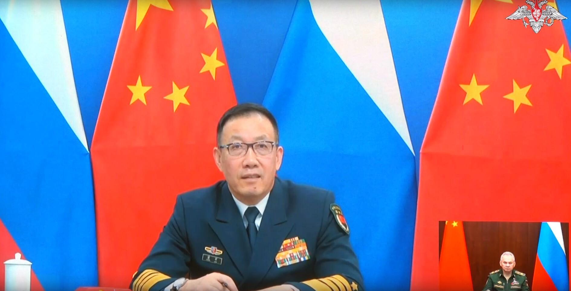 The image is a screenshot from Russian Army TV Channel, which shows a meeting between Chinese Defense Minister Dong Jun and Russian Defense Minister Sergei Shoigu in December 2023. 