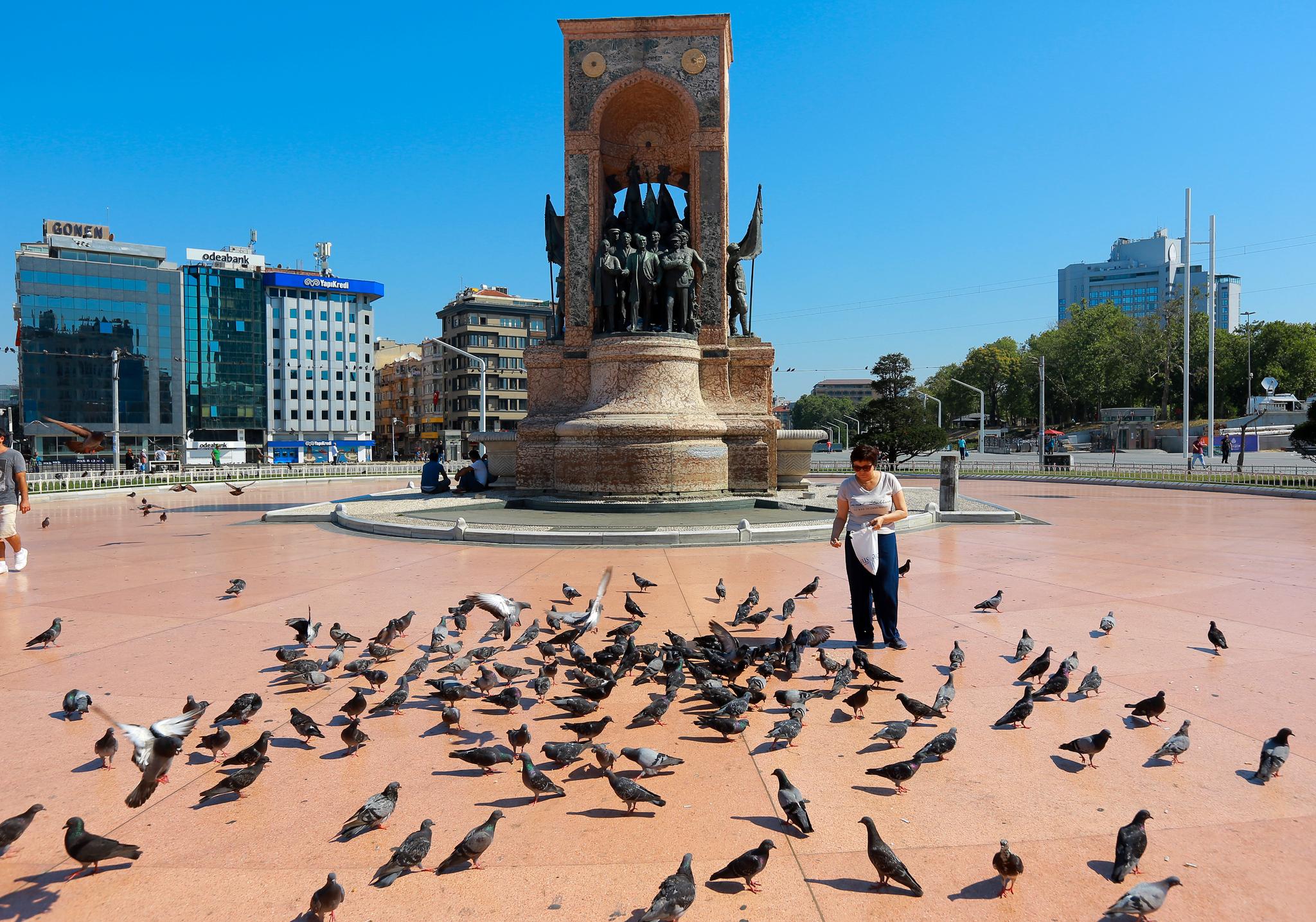 Lørdag morgen så situasjonen ut til å normalisere seg i Istanbul. Her mater en kvinne duene på Taksim-plassen, som var åsted for dramatikk gjennom natten.
