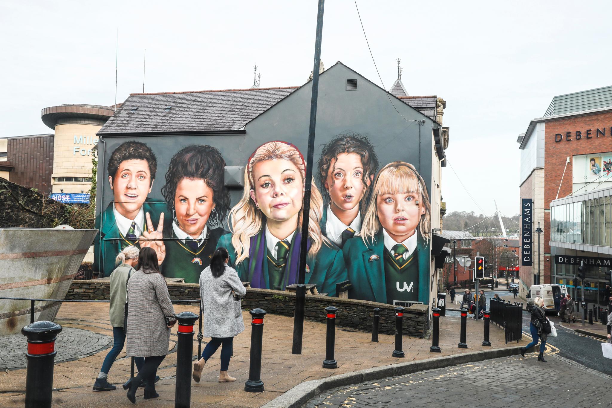 De fem hovedpersonene i serien Derry Girls, som vises på Netflix, er malt opp på en vegg midt i Londonderry/Derry sentrum. Serien beskriver vanlig tenåringsliv i helt uvanlige omgivelser. 
