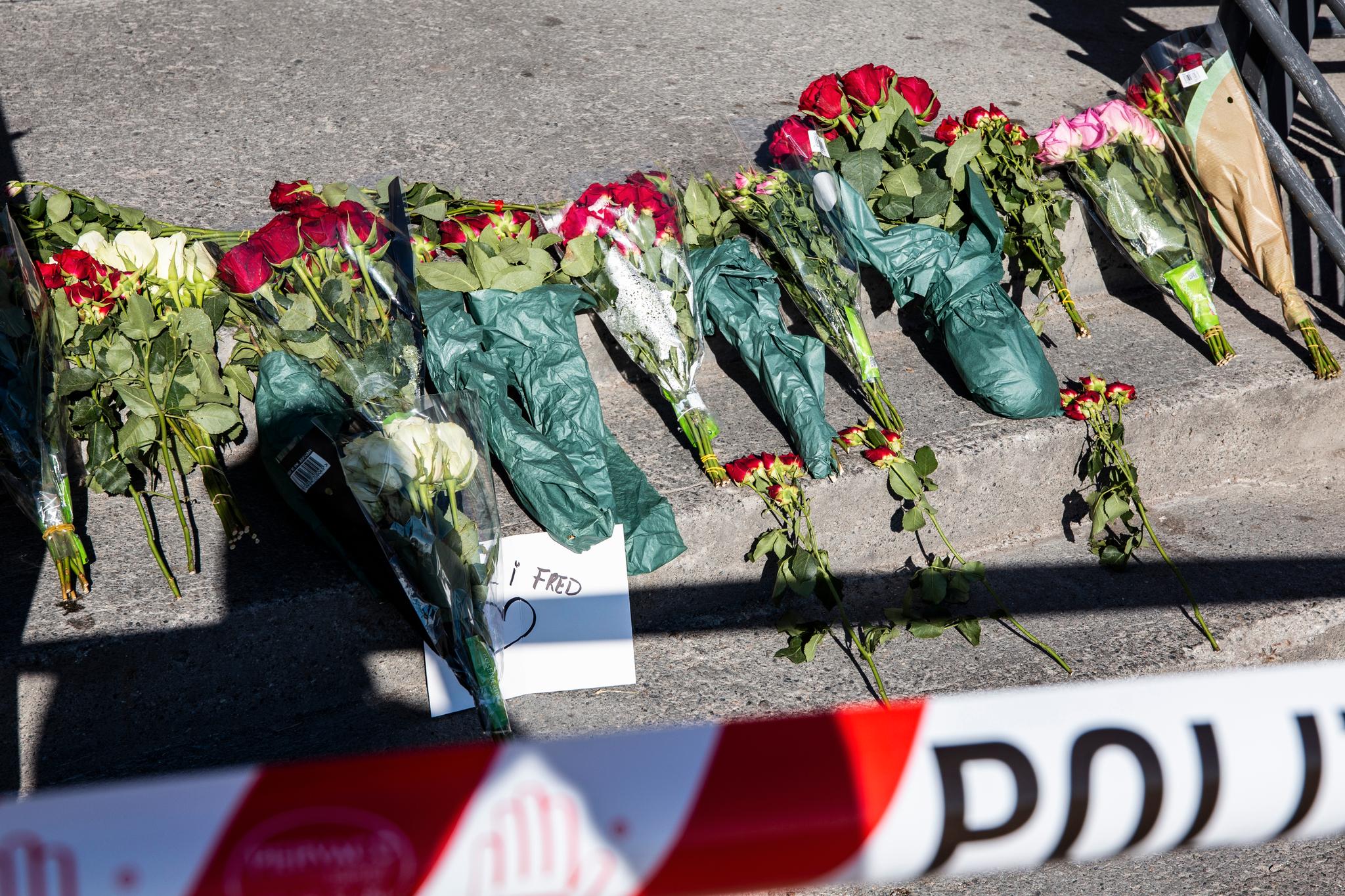 Blomster ved politisperringene utenfor butikken der Håvard Pedersen ble drept.