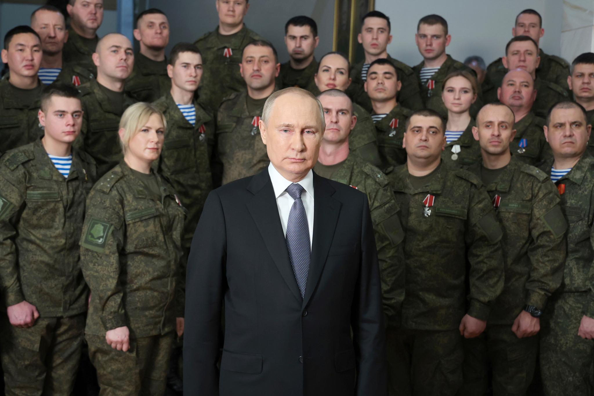 Russslands president Vladimir Putin poserer med militært personell etter sin egen nyttårstale 31. desember 2022.