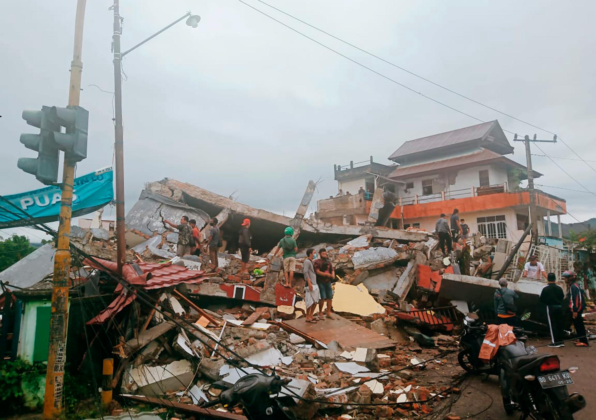 Innbyggere i Mamuju på Sulawesi i Indonesia undersøker skadene etter jordskjelvet fredag. 