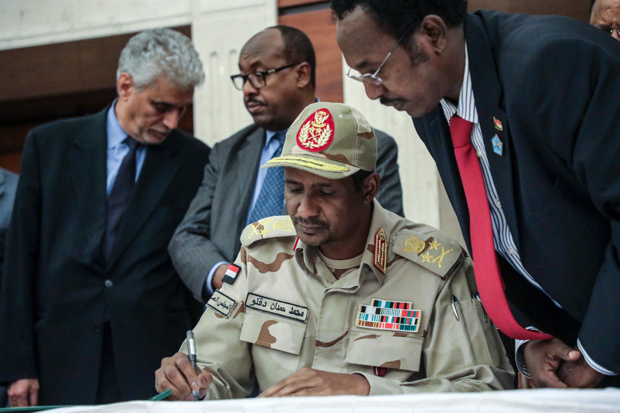 General Mohammed Hamdan Dagalo undertegner en maktdelingsavtale med de opposisjonelle protestlederne i Khartoum lørdag. 