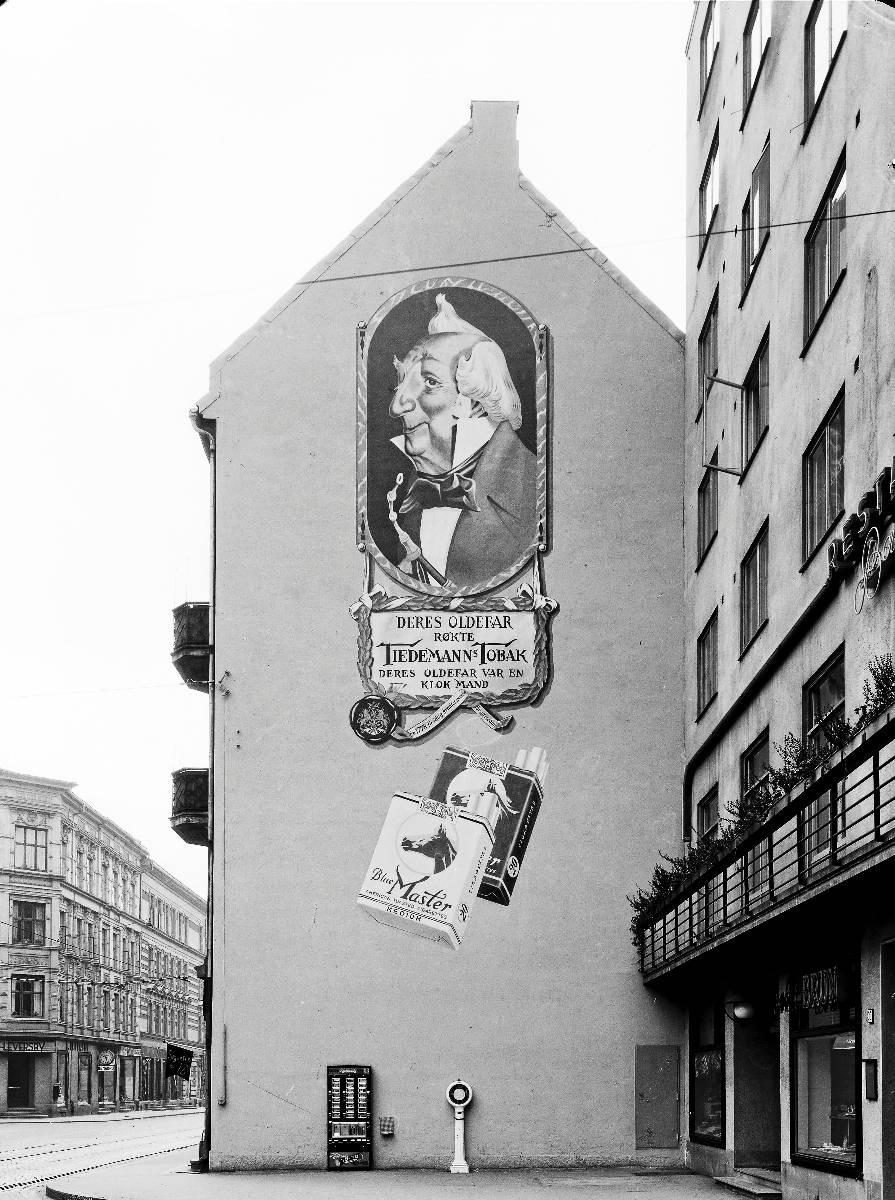 Lenge før reklameforbudet trådte inn, kunne en se tobakksreklamer overalt i byen. Dette bildet er tatt i Bogstadveien i 1953.