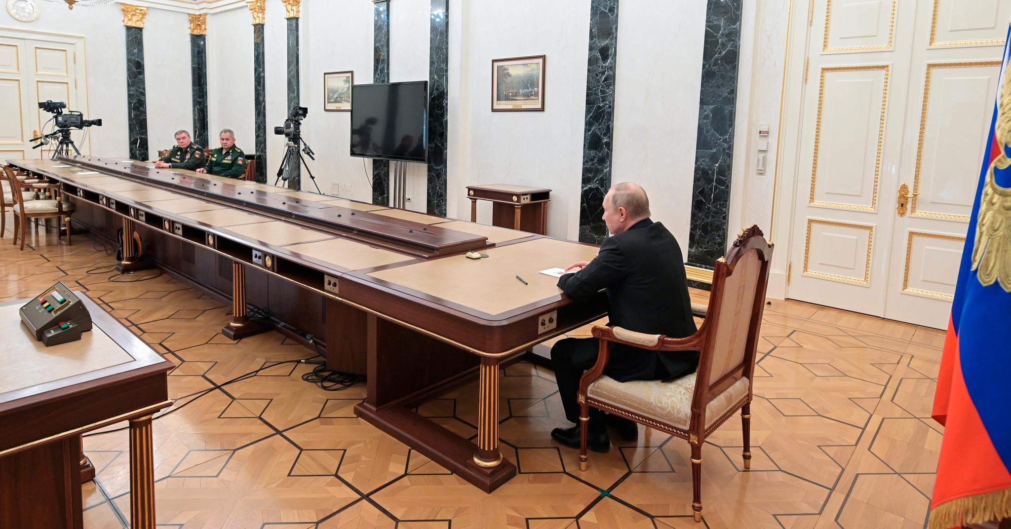 President Vladimir Putin i samtale med forsvarsminister Sergej Sjojgu og forsvarssjef Valerij Gerasimov søndag. Han har bedt dem høyne beredskapen for Russlands atomvåpen.