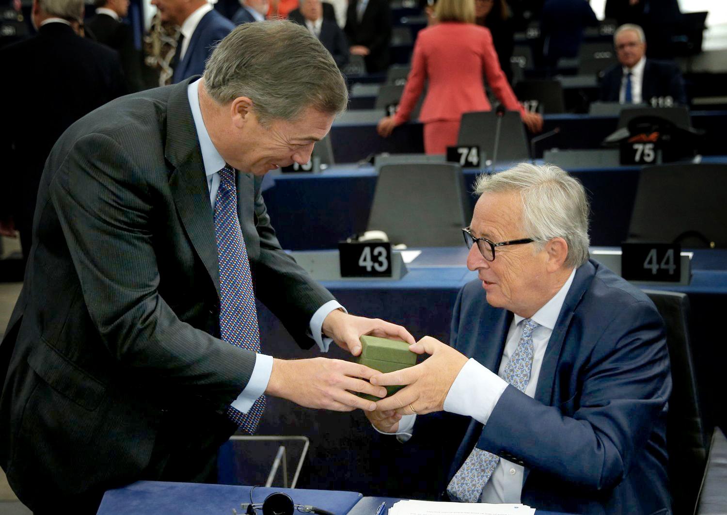 EU-president Jean-Claude Juncker (t.h.) tok motvillig imot gaven fra britenes brexit-general Nigel Farage. Det er liten grunn til å tro at EU-mostanderen, som har hatt for vane å mobbe og skjelle ut EU-ledere, hadde gode hensikter med gaven. Men Juncker lar seg nok «ikke bestikke», hverken av britiske EU-tilhengere eller motstandere.