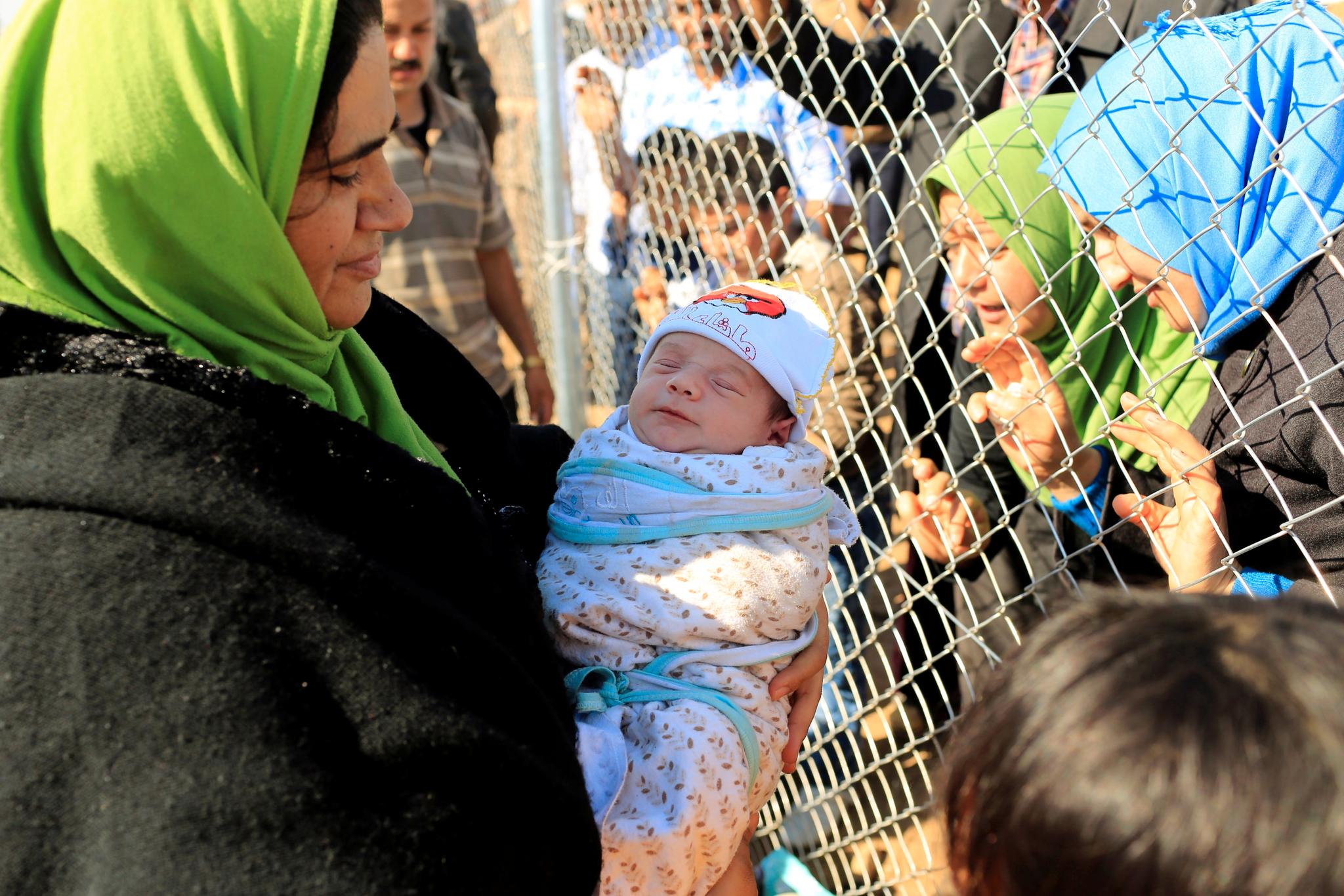 Folk som har flyktet møter slektninger ved Al-Khazer-flyktningleiren utenfor Mosul.