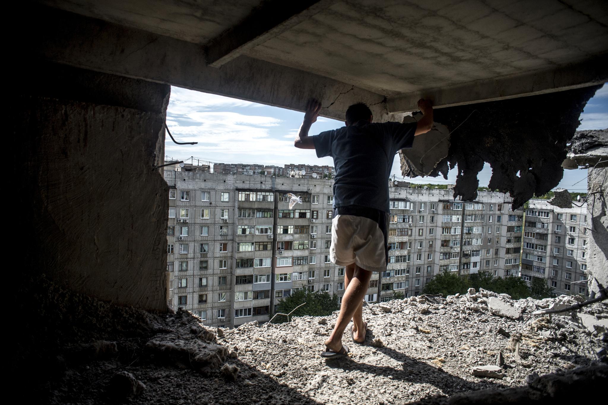 En mann undersøker en ødelagt bygning i Luhansk i Donbass-regionen i Øst-Ukraina.