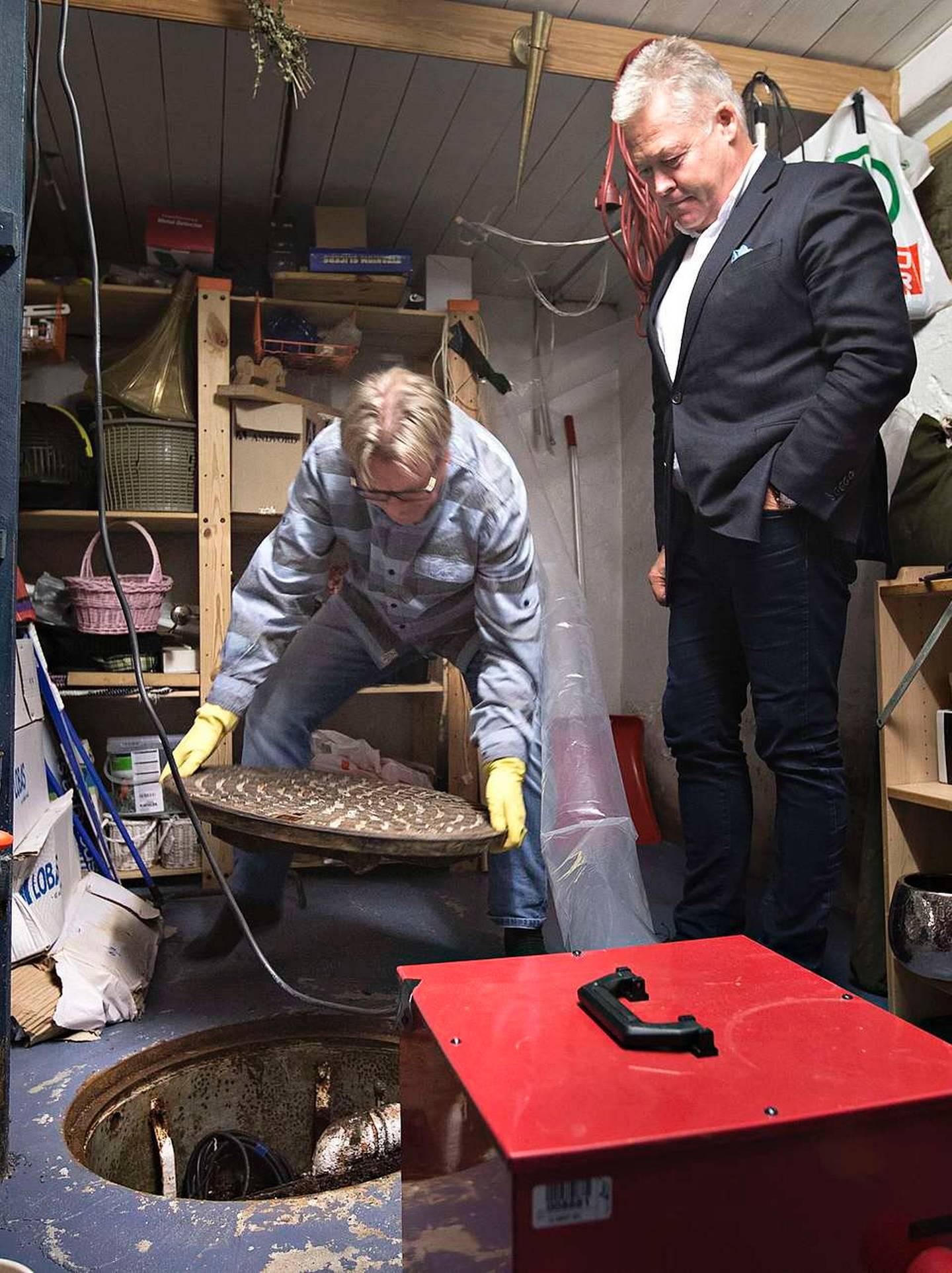 Oddbjørn Solstad viser Gjensidiges konsernsjef Helge Leiro Baastad at familien har gjort alt de kan for å unngå skade. Egen pumpe er montert under kjellergulvet.