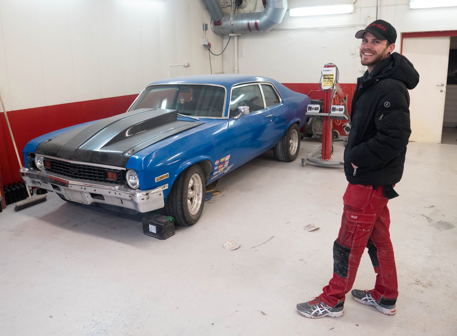 Kristian Evertsen, med en bil som han driver full restaurasjon på i lakkeringslokalet hans.