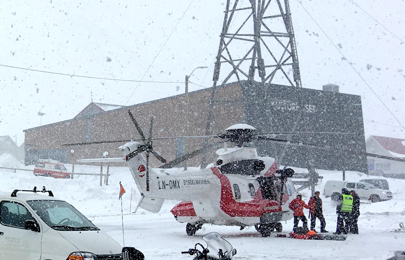 GIKK GJENNOM ISEN: Redningshelikopteret ankommer Longyearbyen med noen av personene i snøskuterfølget.  