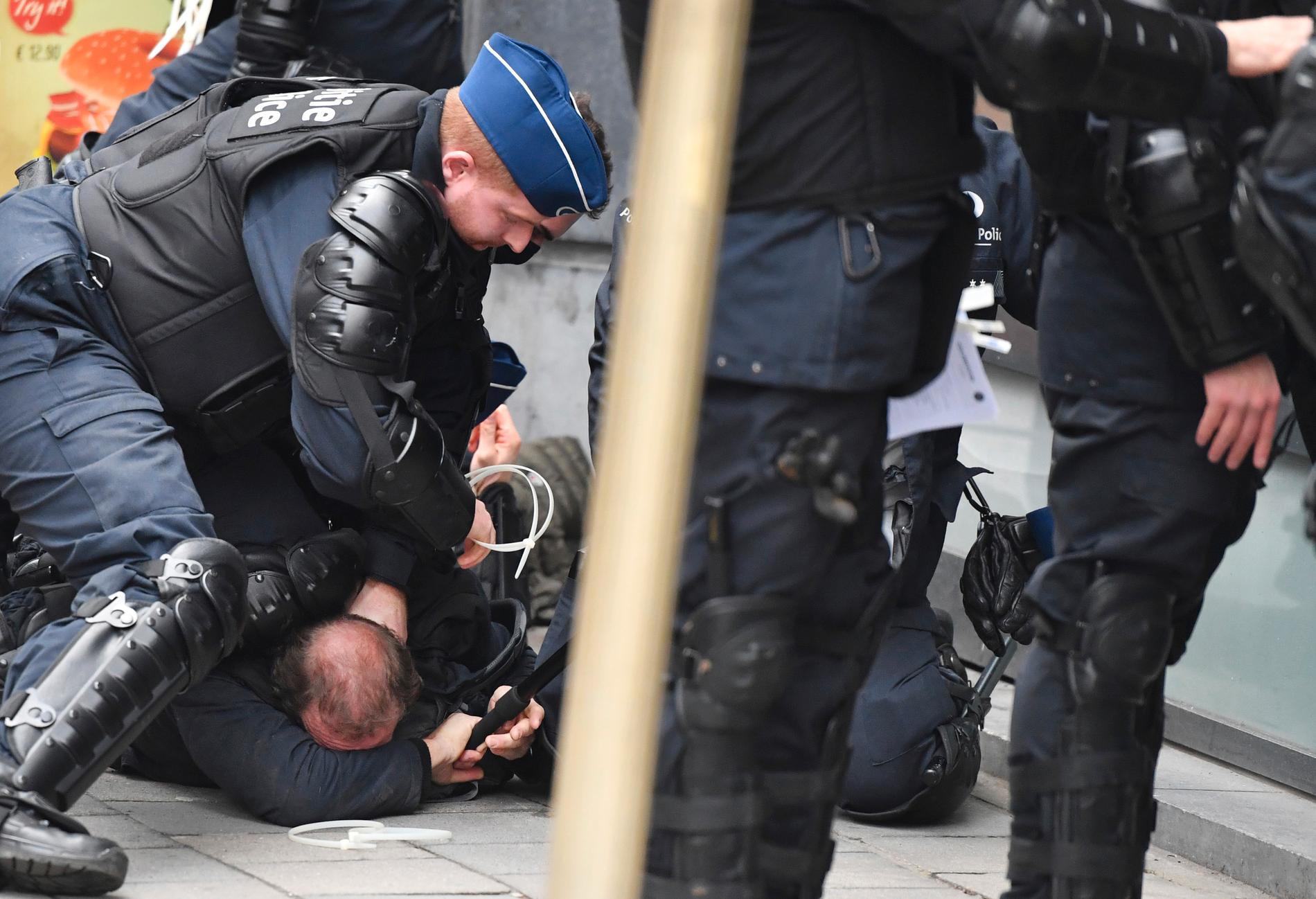 ARRESTERT: Belgisk politi pågriper demonstranter ved EU-kvartalet i Brussel lørdag. 