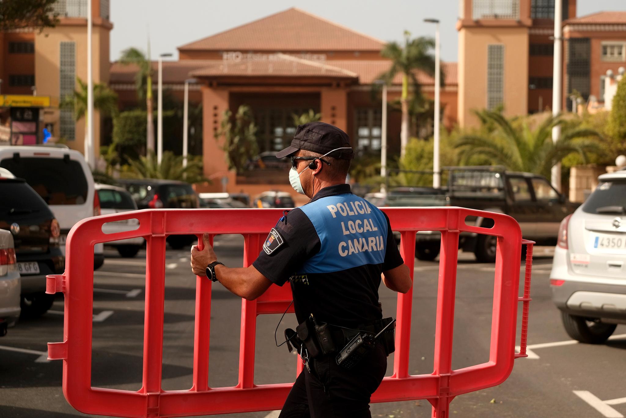 En politimann setter opp en sperring ved innkjøringen til hotellet H10 Costa Adeje Palace på Tenerif.