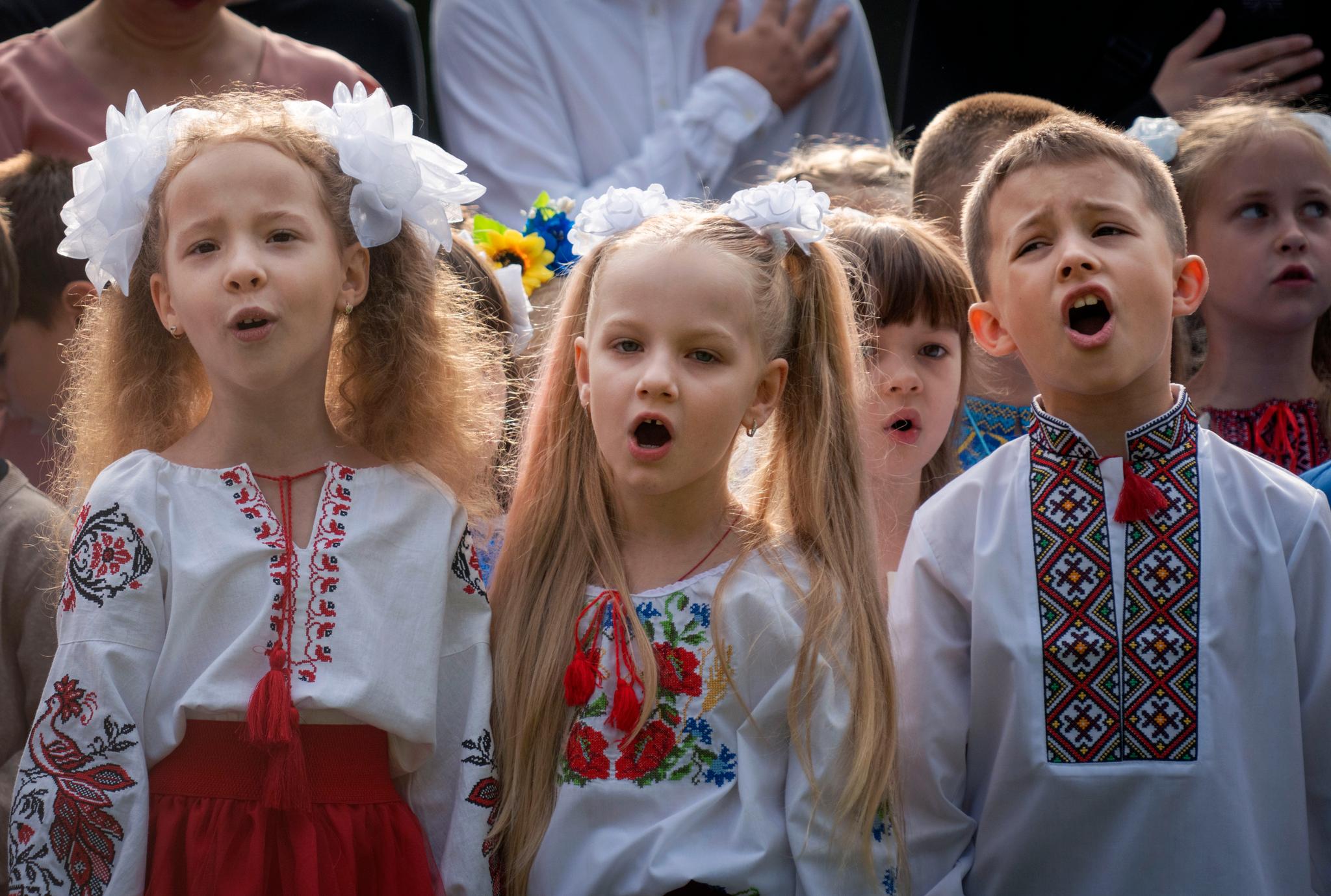 Ukrainske skolebarn synger nasjonalsangen på første skoledag i Butsja. Mange barn som har flyktet fra Ukraina, får ikke samme muligheten til å gå på skole. Skolehverdagen kan også fort bli brutt opp i Ukraina. FN er bekymret for fremtiden til Ukrainas barn. 