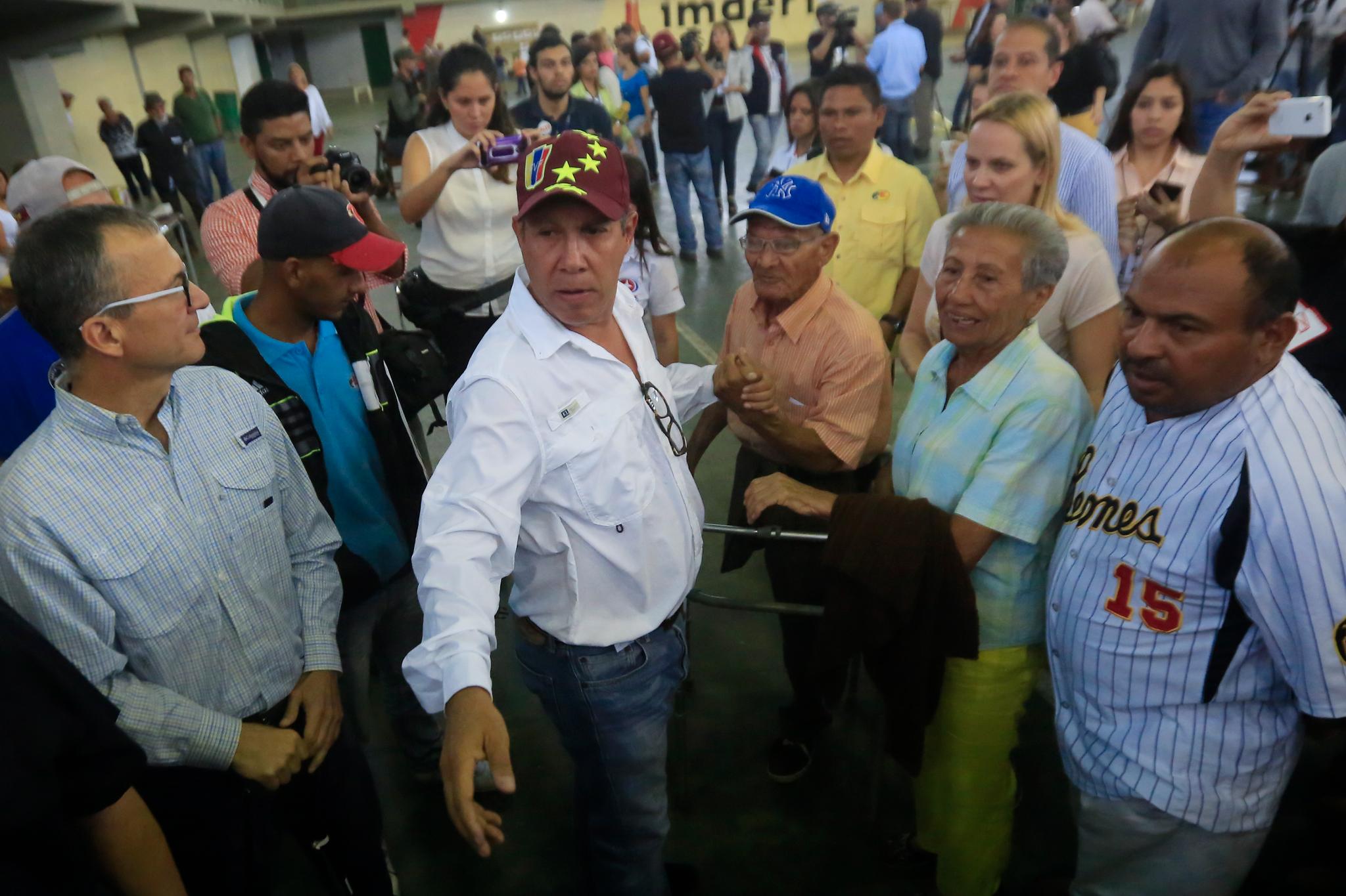 Presidentkandidat Henri Falcón står sammen med flere støttespillere søndag. Han sier valget i Venezuela mangler legitimitet og krever et nytt.