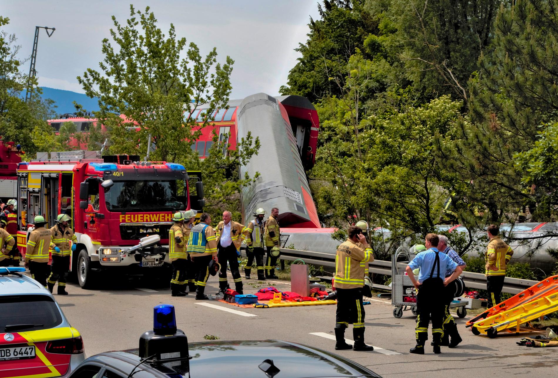 En rekke nødetater og redningsarbeidere jobber på stedet der et tog sporet av i Garmisch-Partenkirchen fredag. 