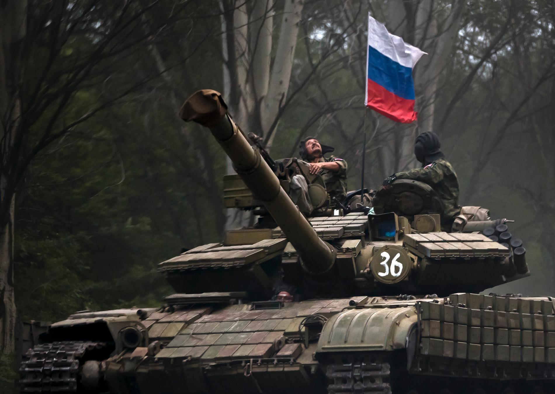 Russiskstøttede separatister på en stridsvogn i utbryterregionen Donetsk i Øst-Ukraina. Stridsvognen er utstyrt med et russisk flagg. 