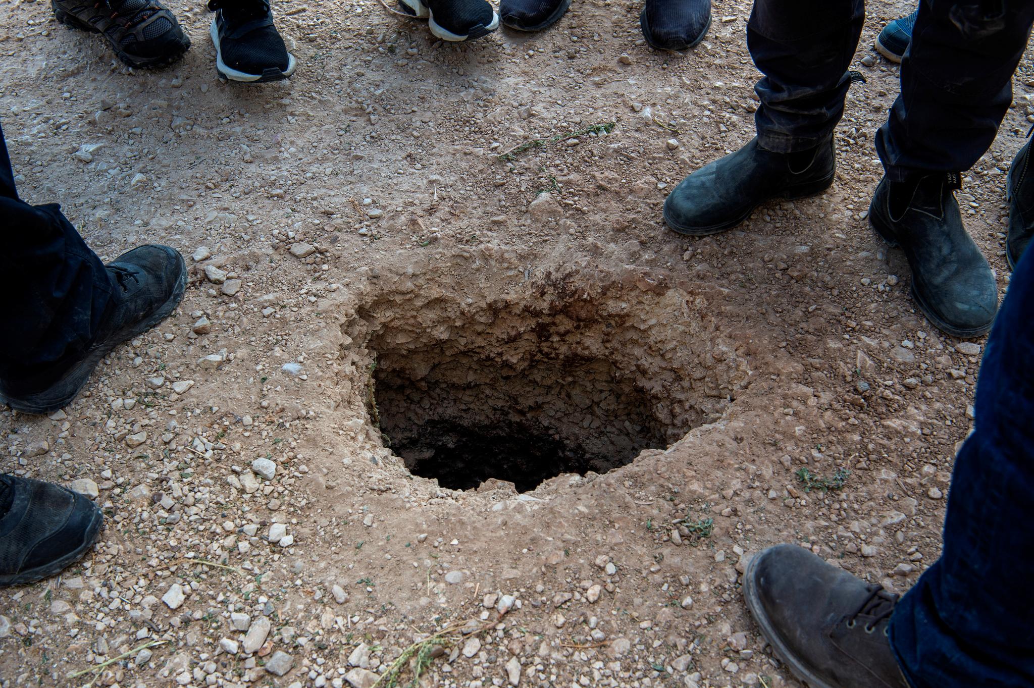 Israelske politifolk undersøker hullet der de seks fangene skal ha kommet ut.