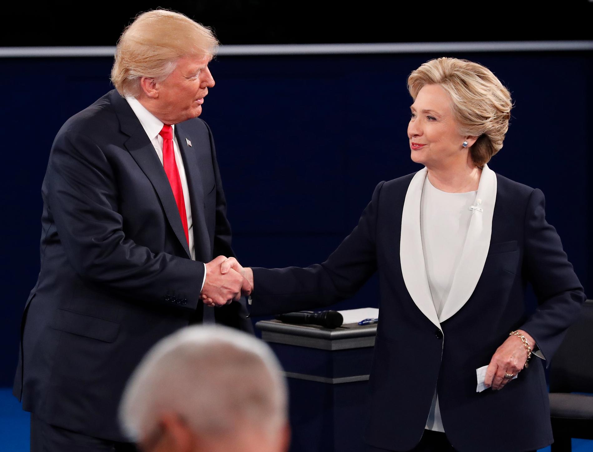 HÅNDHILSTE: Donald Trump og Hillary Clinton takker for kampen etter endt debatt i St. Louis natt til mandag norsk tid. Debatten hadde til tider høy temperatur. De håndhilste ikke før debatten, men gjorde det etter at den var ferdig.