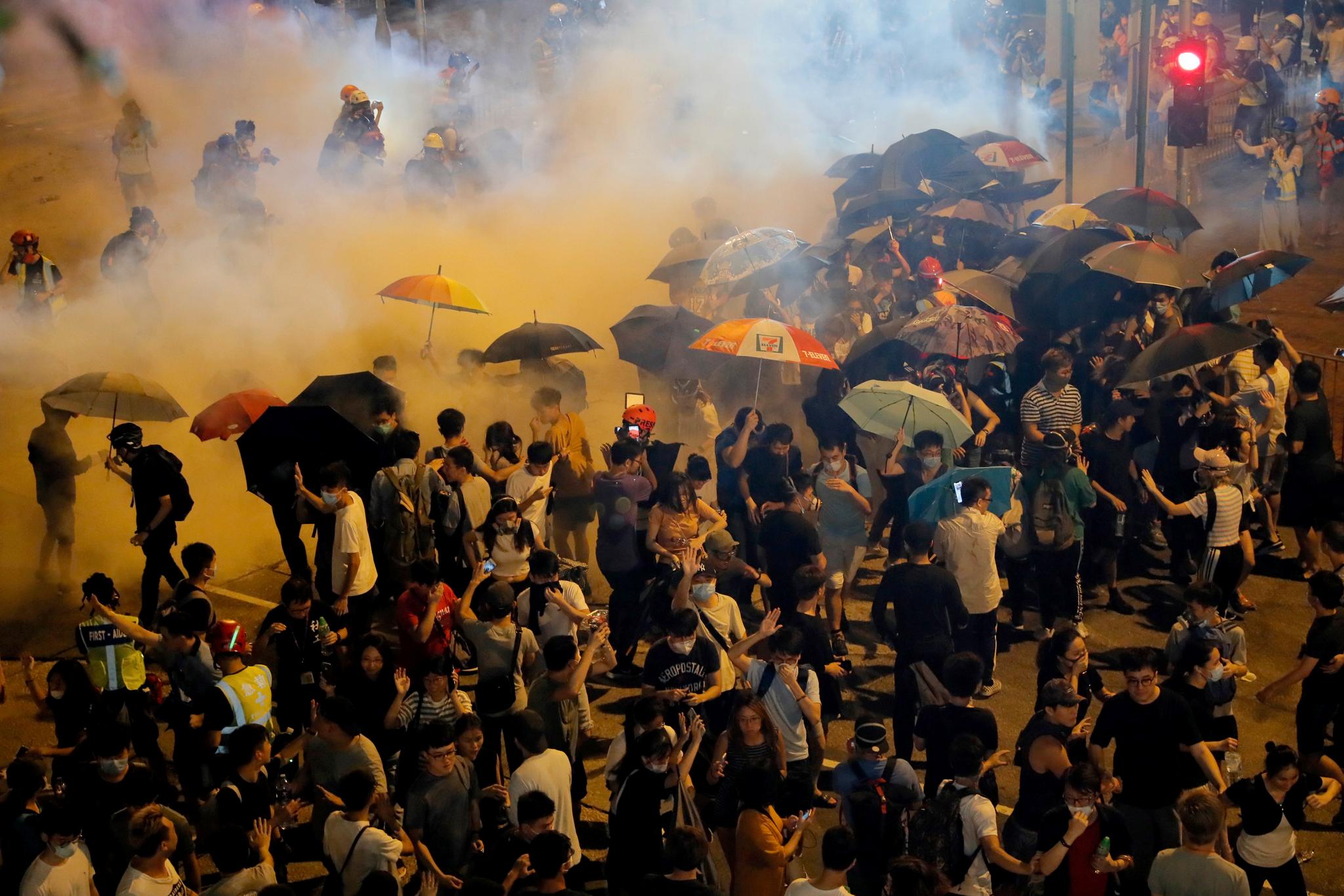 Politiet avfyrte tåregass mot en folkemengde i Wong Tai Sin-distriktet i Hongkong lørdag. Foto: Kin Cheung / AP / NTB scanpix